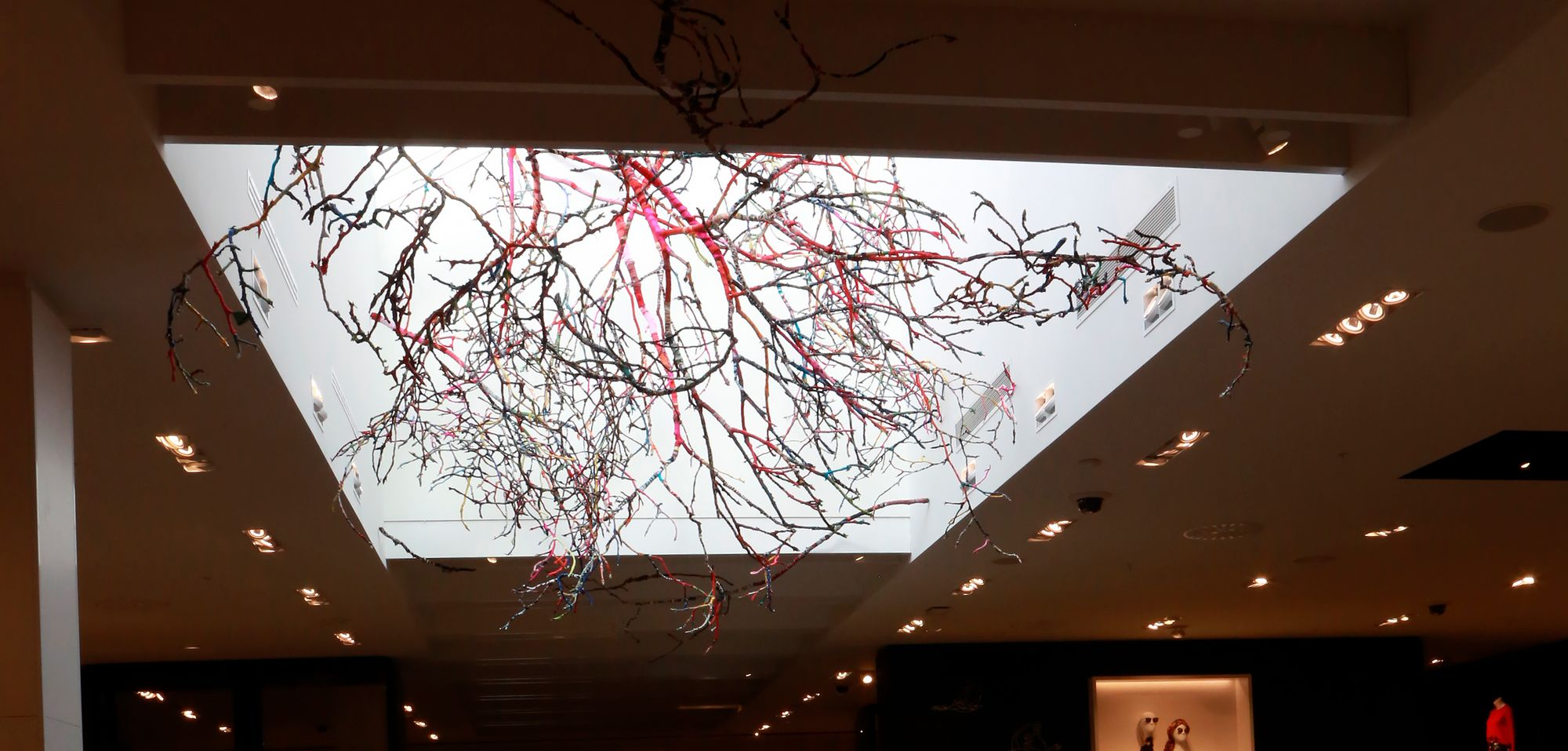 ('La Cime' art installation, which is composed of branches hanging at different heights in the skylight located at the centre of the store. It represents an inverted landscape composed of wooden branches that are covered in papier-mâché and fabric recycled by Simons customers and the design team. 