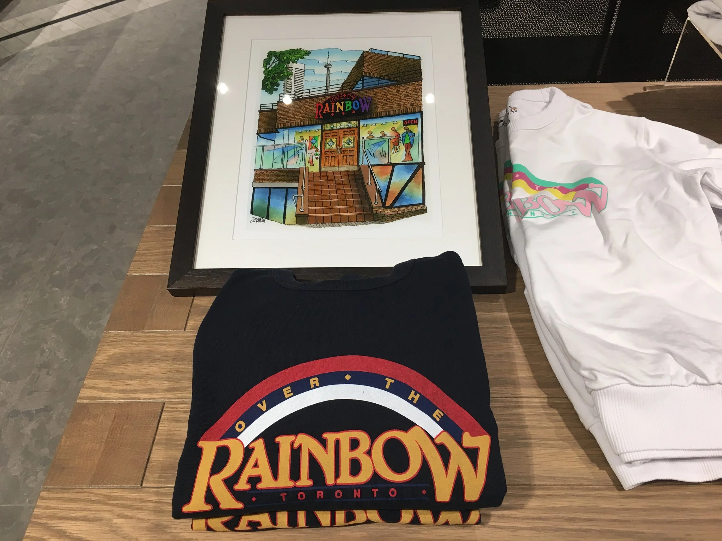 A framed photo of the former 101 Yorkville Avenue Over the Rainbow storefront, as well as sweatshirts with the former branding. Photo: Craig Patterson