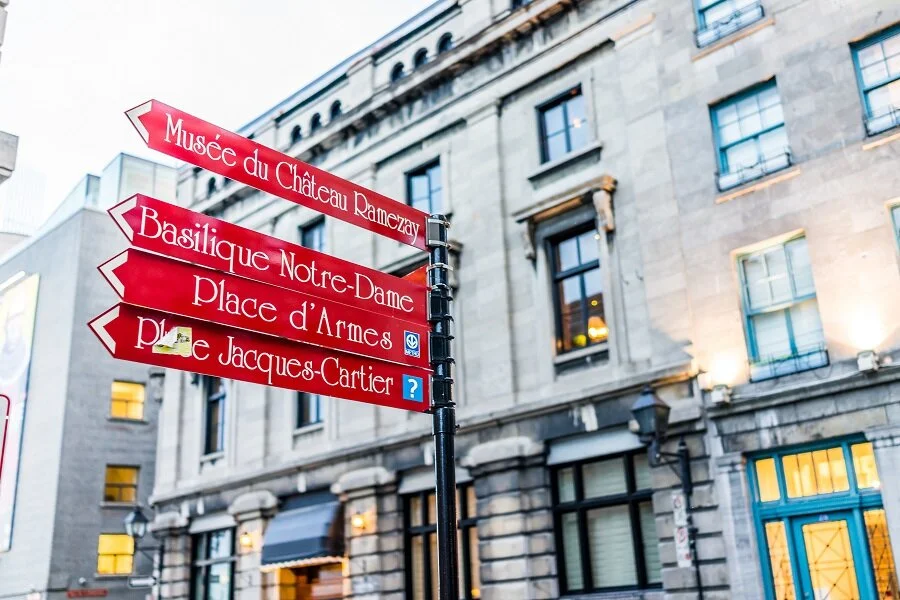 red direction signs in old town area of Montreal. Photo: Kristina - stock.adobe.com