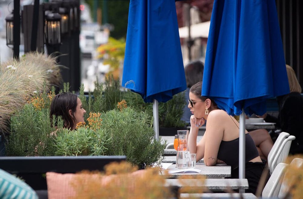 Two women have drinks on the patio of a restaurant in Vancouver, on May 19, 2020. British Columbia has begun reopening its economy. photo: THE CANADIAN PRESS/Darryl Dyck