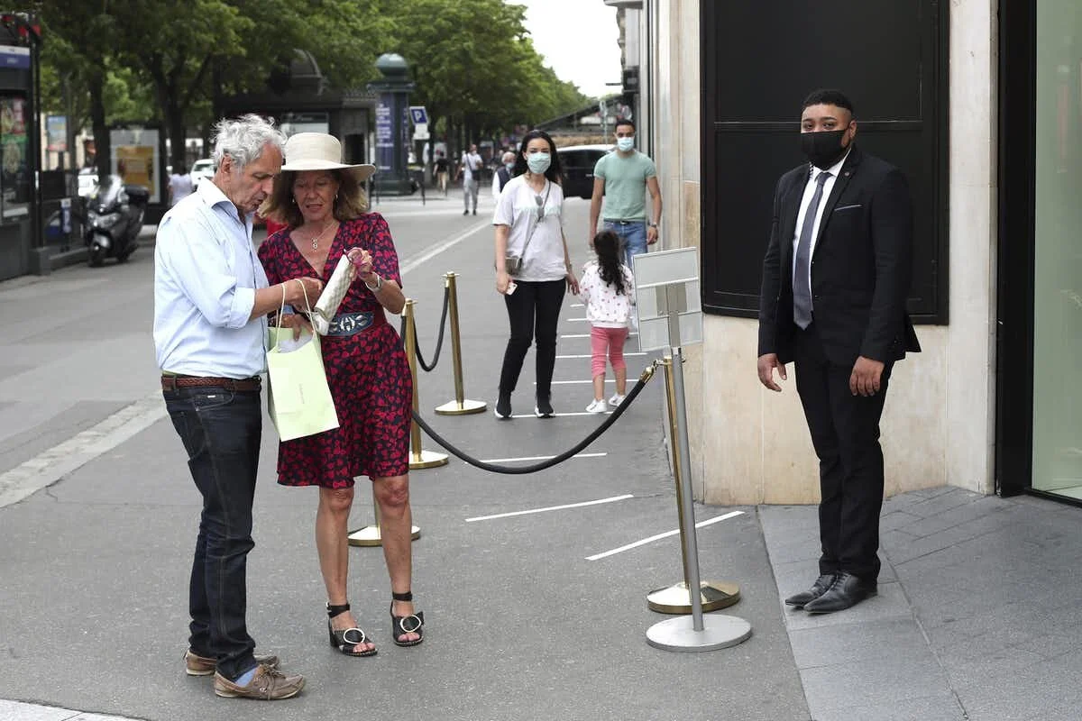 People wait outside the Louis Vuitton shop on Champs-Élysées Avenue in Paris on June 3, 2020. (AP Photo/Thibault Camus)
