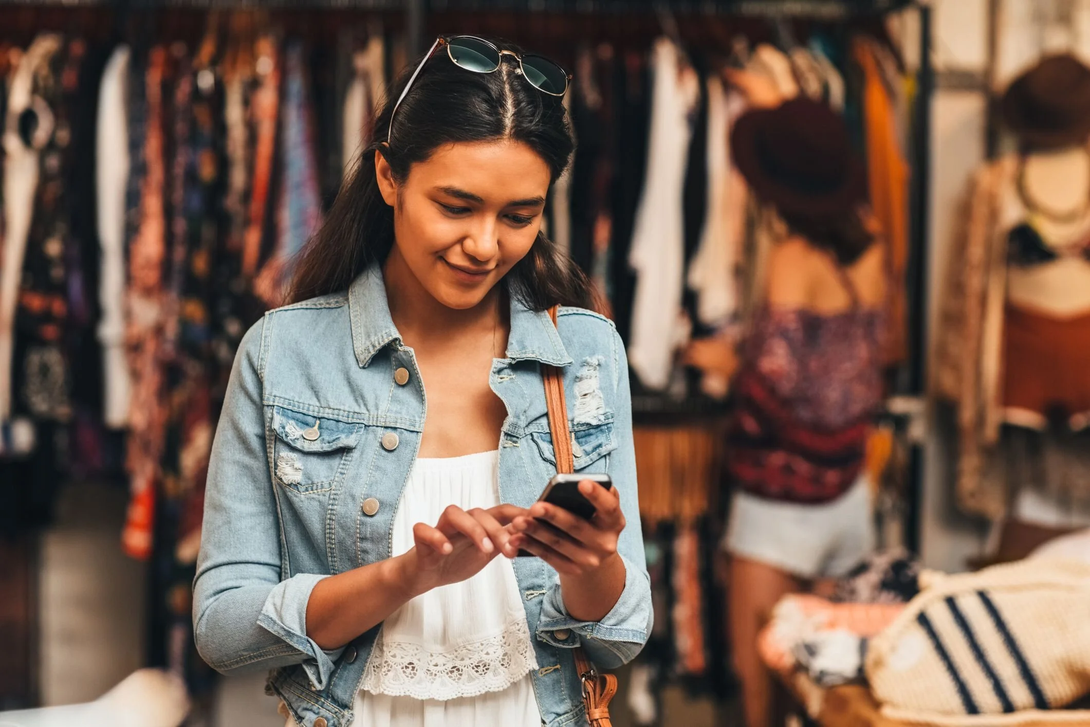 gen z shopper browses in store while checking her phone