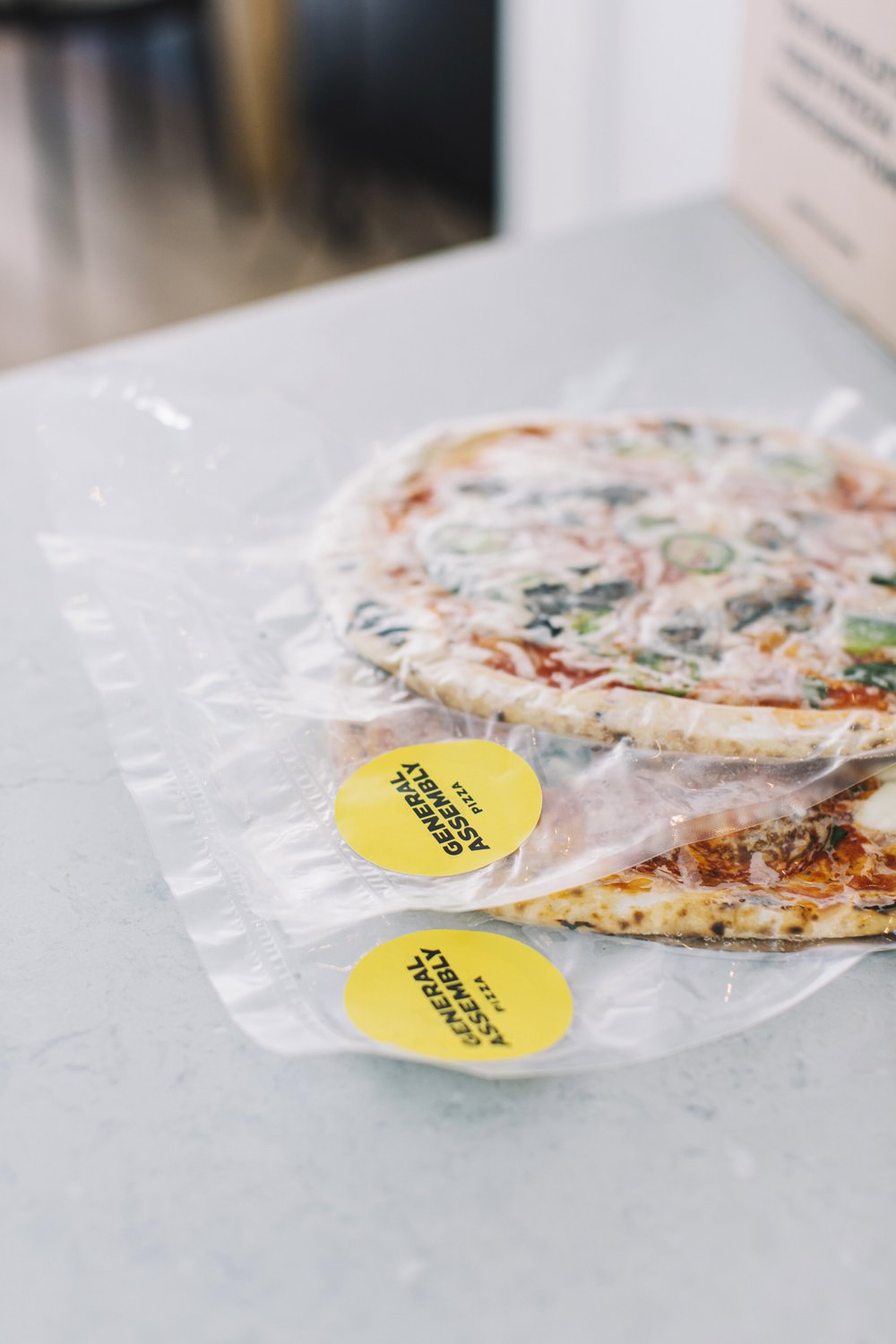 general assembly subscription user opening delivery box of pizza. photo: general assembly pizza