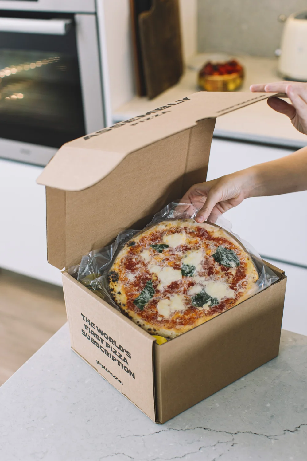 general assembly subscription user opening delivery box of pizza. photo: general assembly pizza