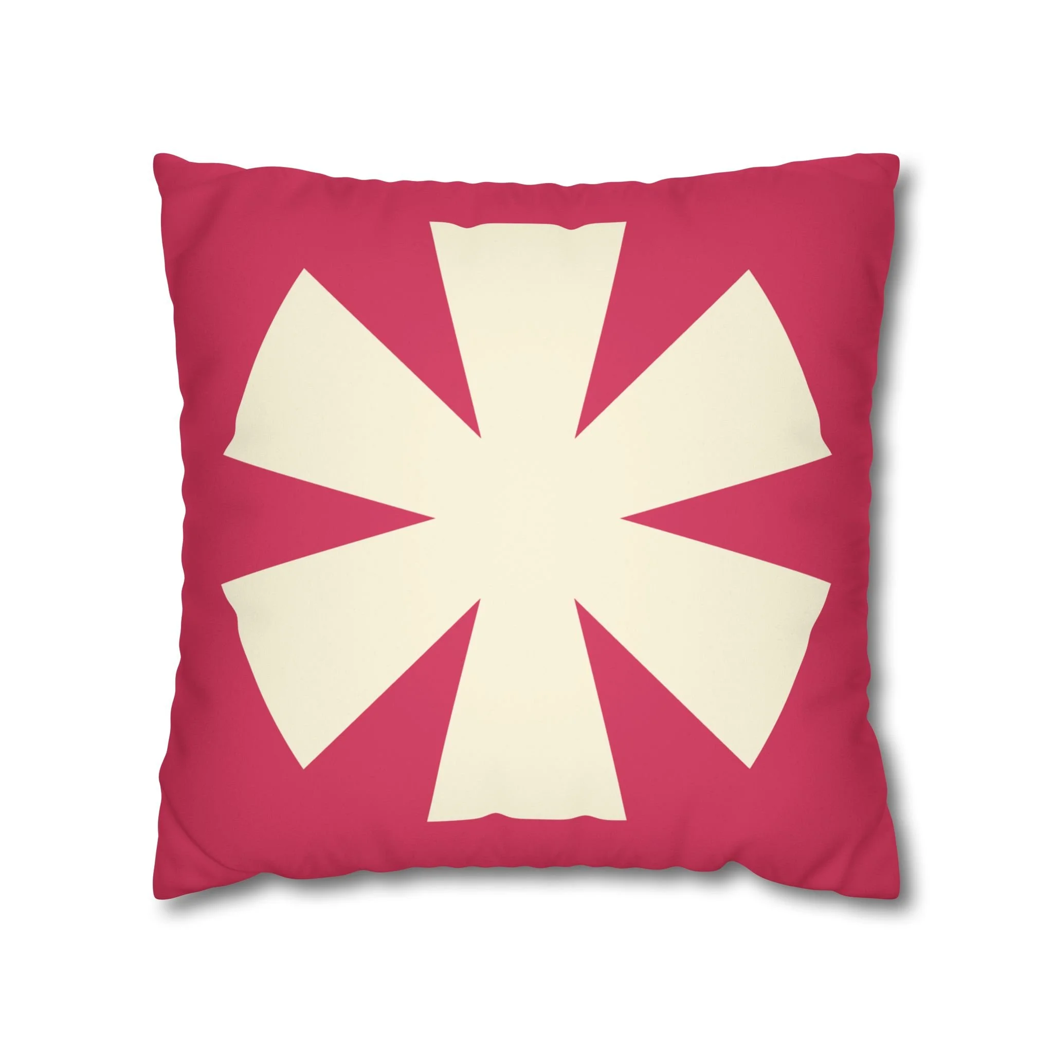 Pink decorative pillow with a white geometric flower pattern in the center.