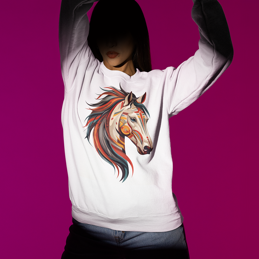 Animal spirit shirt featuring a stylized Mustang head on a white sweatshirt, worn my a young woman on a violet background. She is in shadow except for a spotlight on the shirt and her torso.