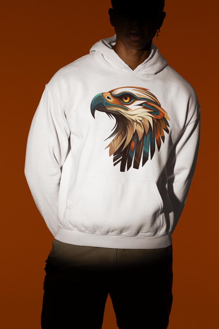 Man wearing a white hoodie with a colorful eagle head graphic on the front, standing against a dark red background.