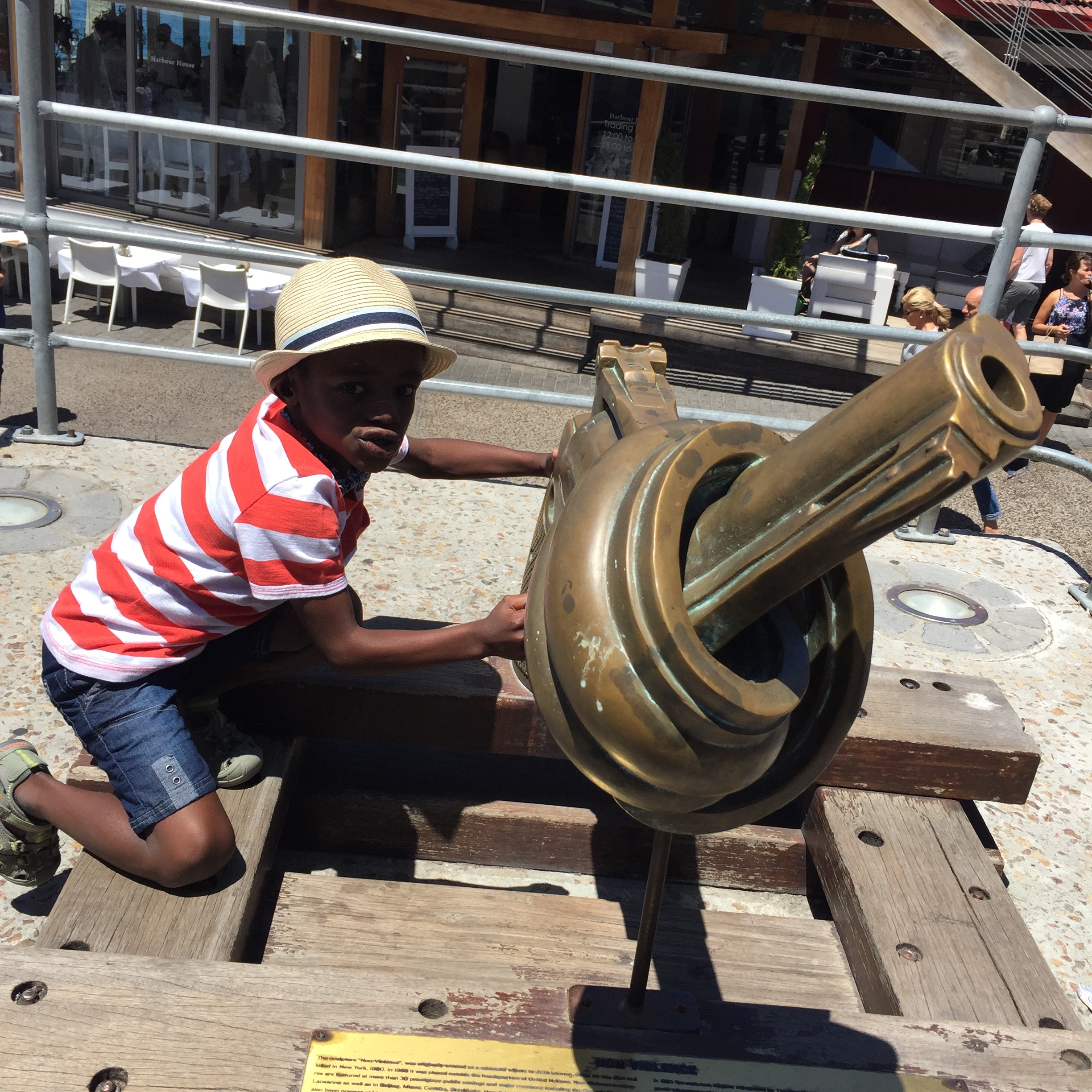 Our son shooting at people with the sculpture titled "Non-Violence"