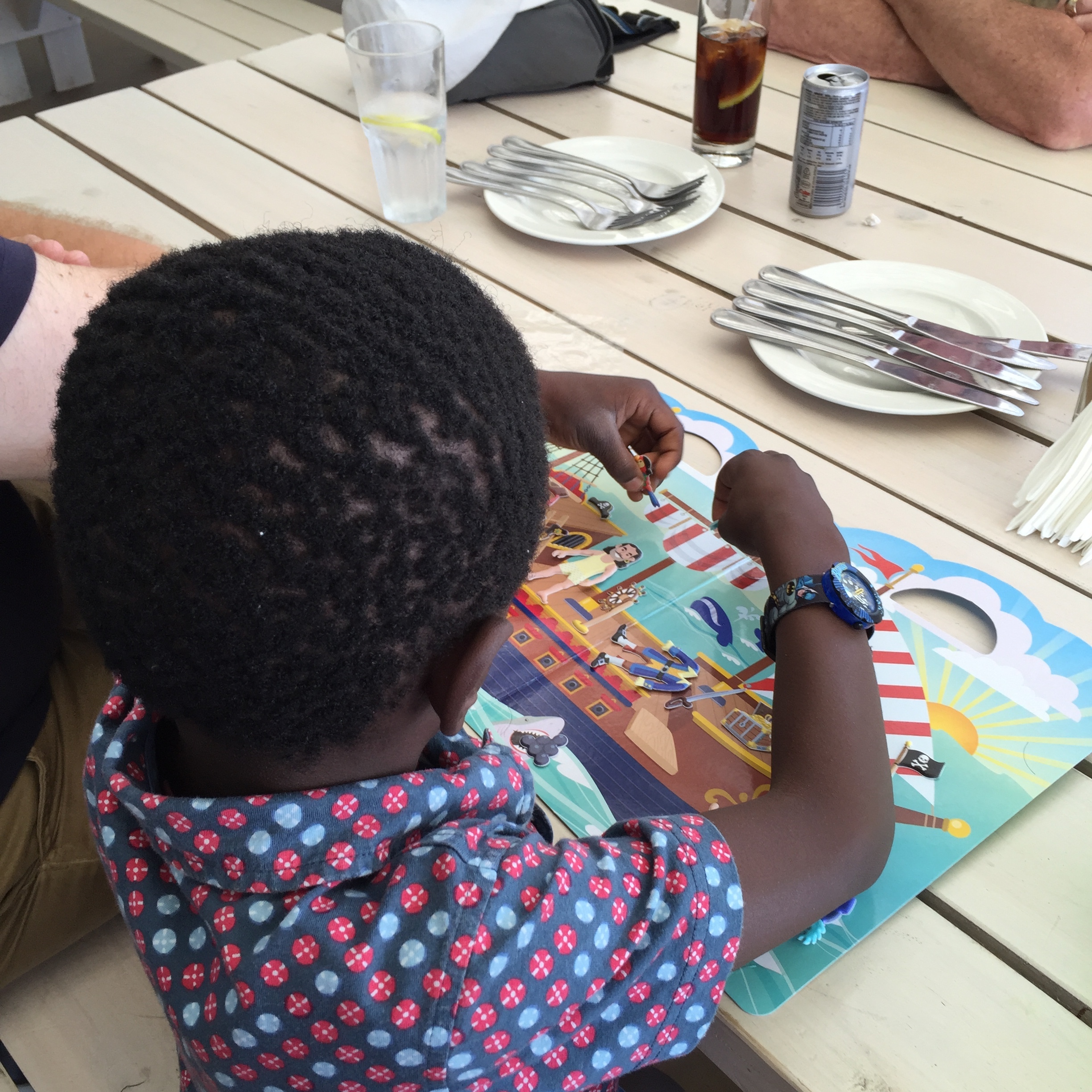 Tisetso entertaining himself before the food came with his new pirate sticker book.