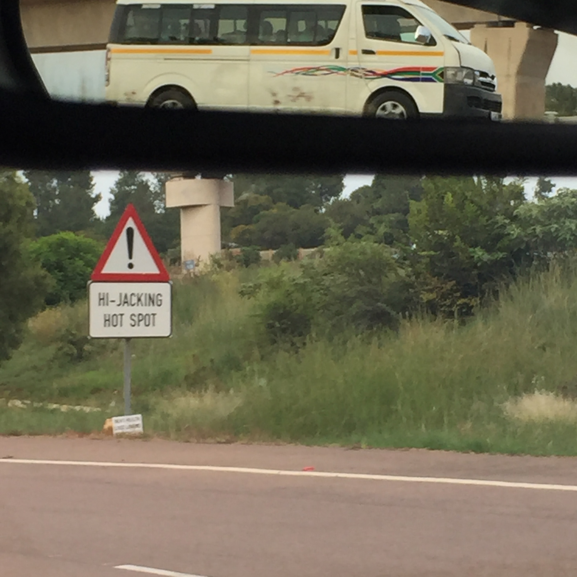I was trying to take a photo of this terrifying road sign, but also managed to capture a speeding taxi in our rearview mirror.