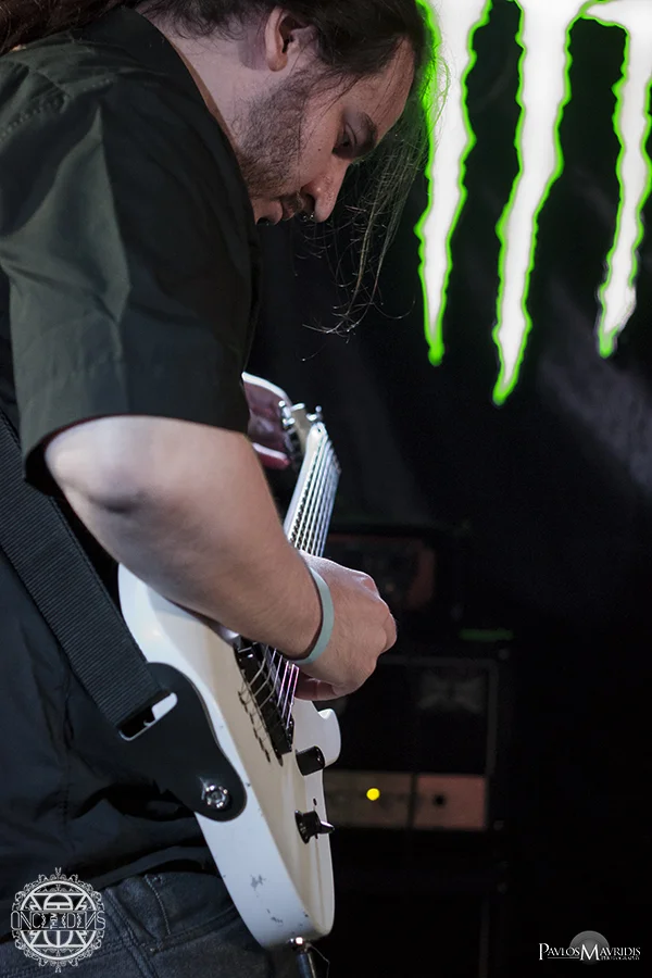 "Ω", the band's mastermind tuning his guitar.