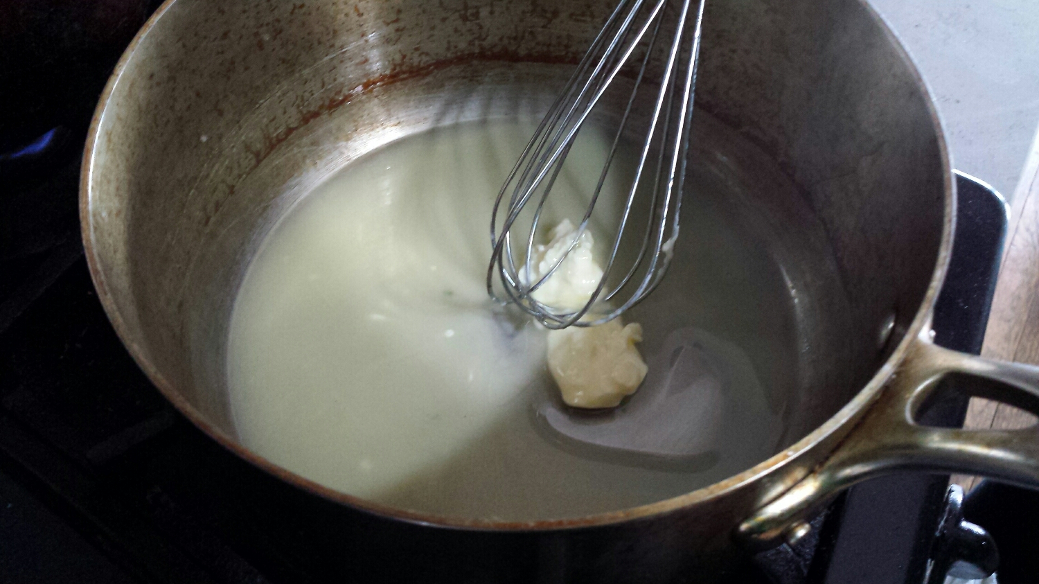 Slowly melt 4 TBS of butter in a sauce pan until the butter lightly coats the bottom of the pan. Meanwhile, bring a small sauce pan of water to a gentle simmer - this will be used in a few minutes to double boil the hollandaise sauce. Also fill a nonstick saute pan with water and bring to a simmer. When simmering, add 2 TBS of white wine vinegar. This will be used to poach the eggs.