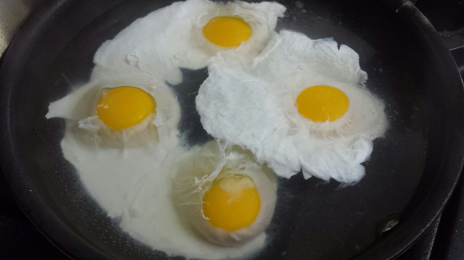 Crack one or two eggs per person into the simmering water/vinegar. Allow the eggs to cook for four minutes.