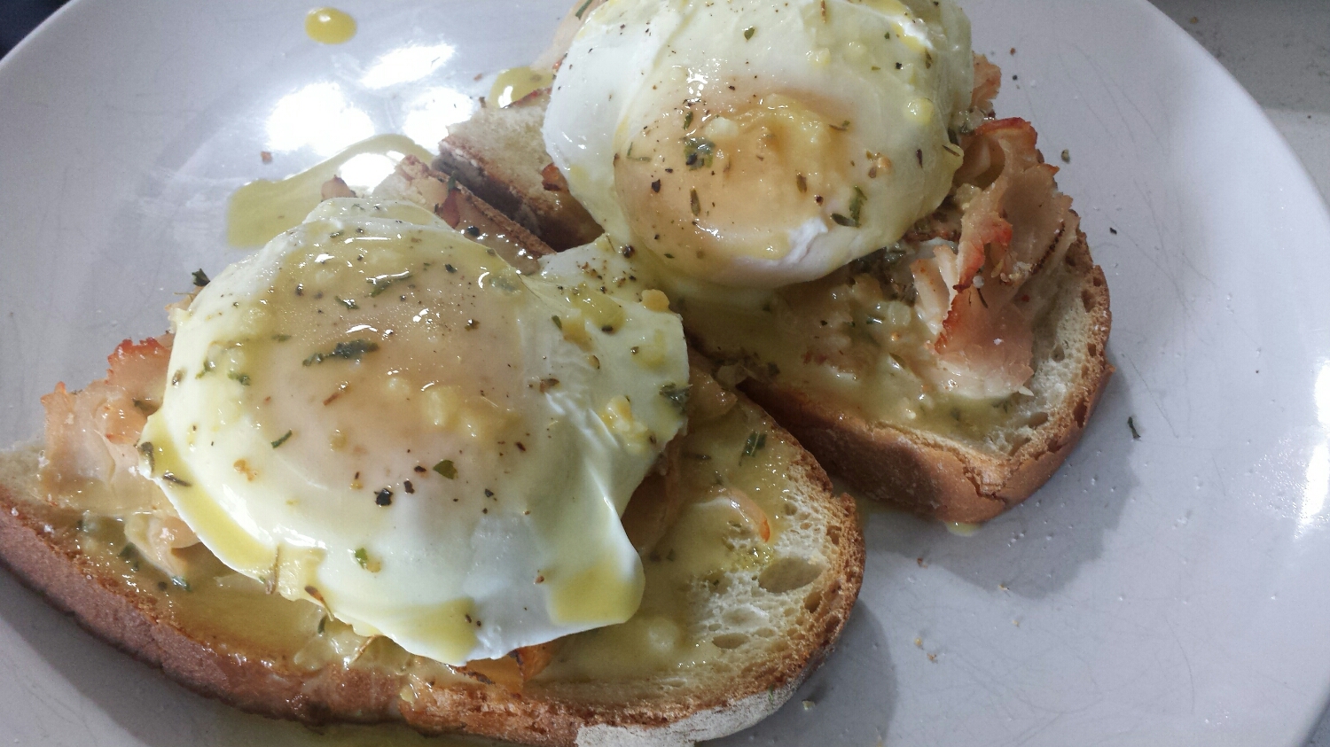 Remove the bread from the oven and place on a plate. Gently scoop the eggs from the saute pan and place on top of the bread/meat. Top the dish with hollandaise and, voila! Brunch is ready!
