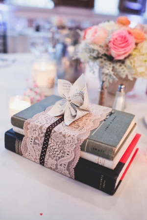 Sometimes, less is more. As proven by these simple centerpieces of books wrapped with lace and a book page flower.