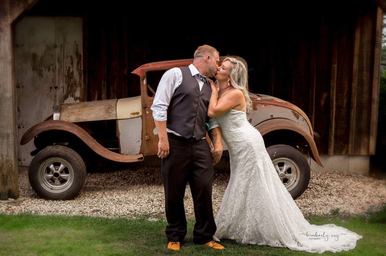 Carlene and Gord Ficht, A Once Upon A Time Weddings bride with her groom, using an antique car as decor at their wedding.