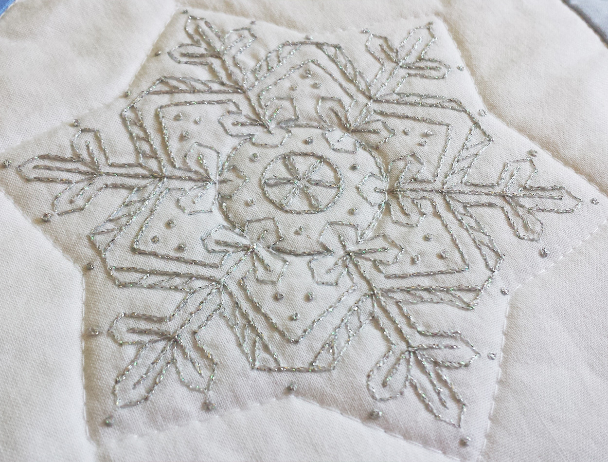 Large snowflake on the quilt using Kreinik floss.