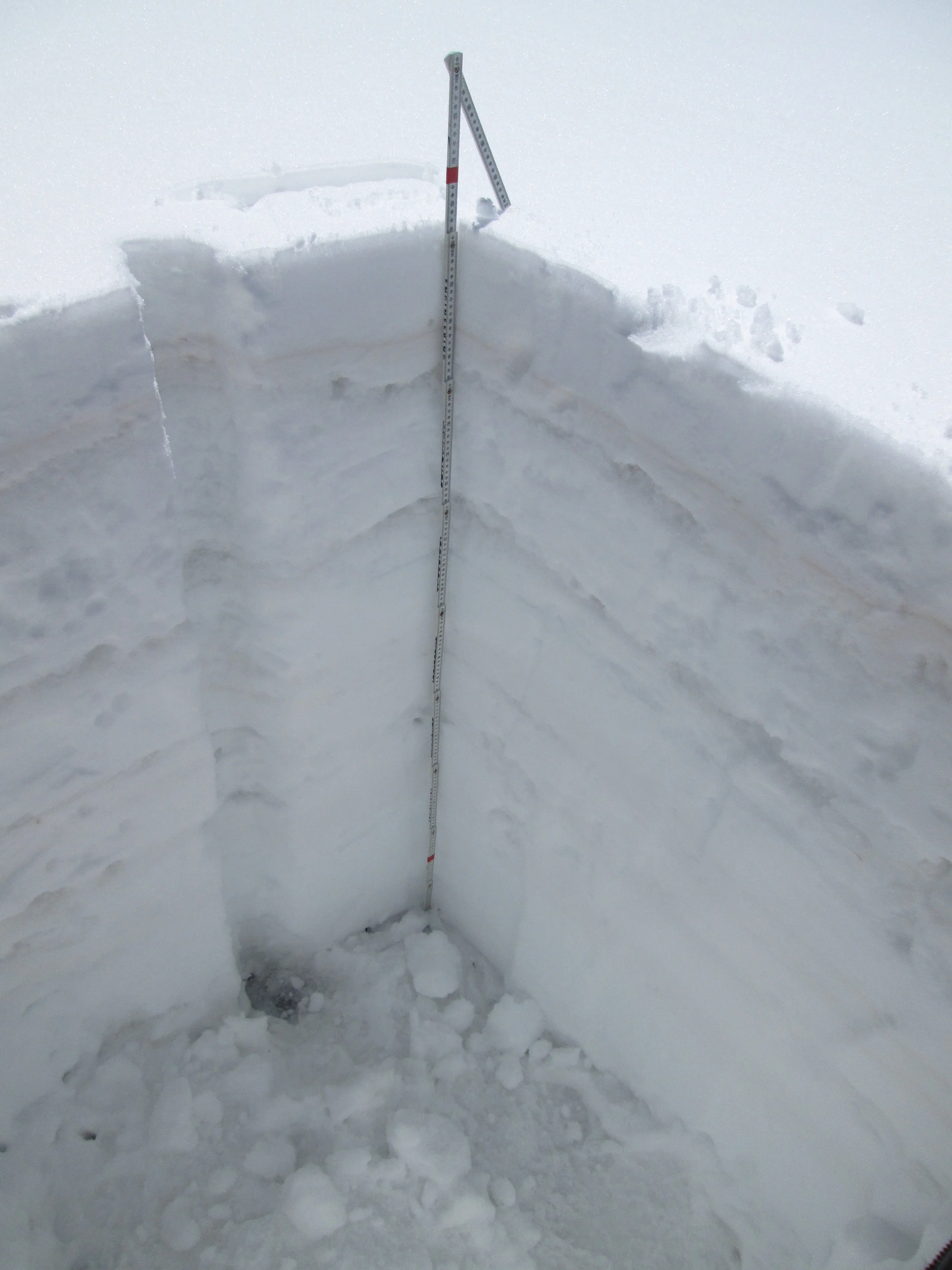 The March 29 snow profile at the Wolf Creek Pass CODOS site. Dust layer D3-WY2014 is clearly visible in a diffuse band 6” below the snow surface. Dust layer D2 may have been present in the thick layer of ice just below D3, but was not visible. Dust layer D4 (March 30) fell onto the clean snow surface seen in this profile, significantly reducing snow albedo until fresh snowfall beginning today (April 2) began to bury D4. Once re-exposed, radiative forcing in layer D4 will need to melt approximately 1” of underlying SWE before merging with layer D3, reducing snow albedo even further.