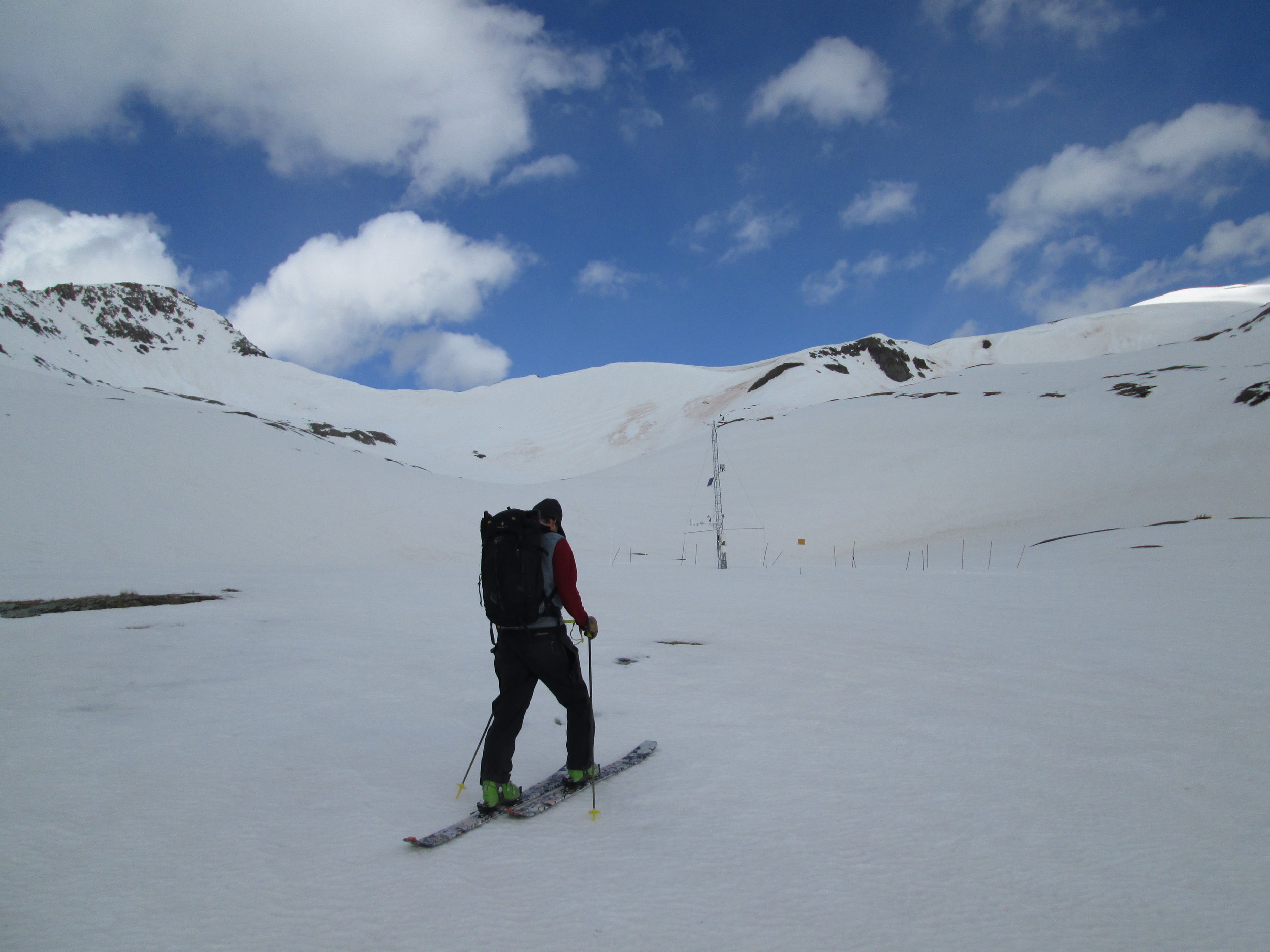 Andrew Temple approaching the Senator Beck Study Plot, at 12,180’, on May 21st. Dust layer D8 was widespread and is clearly evident on the snow surface to the right of the tower. The very dirty patches below the distant ridgeline are merged D3-D8 dust. Much of the dust in the alpine terrain in Senator Beck Basin is still buried underneath Storm #23 and #24 snow but dust layer D8 is accelerating the ablation of that cleaner snow. Mid-day albedo was 0.61 (61% reflectance), reduced by dust layer D8 only.
