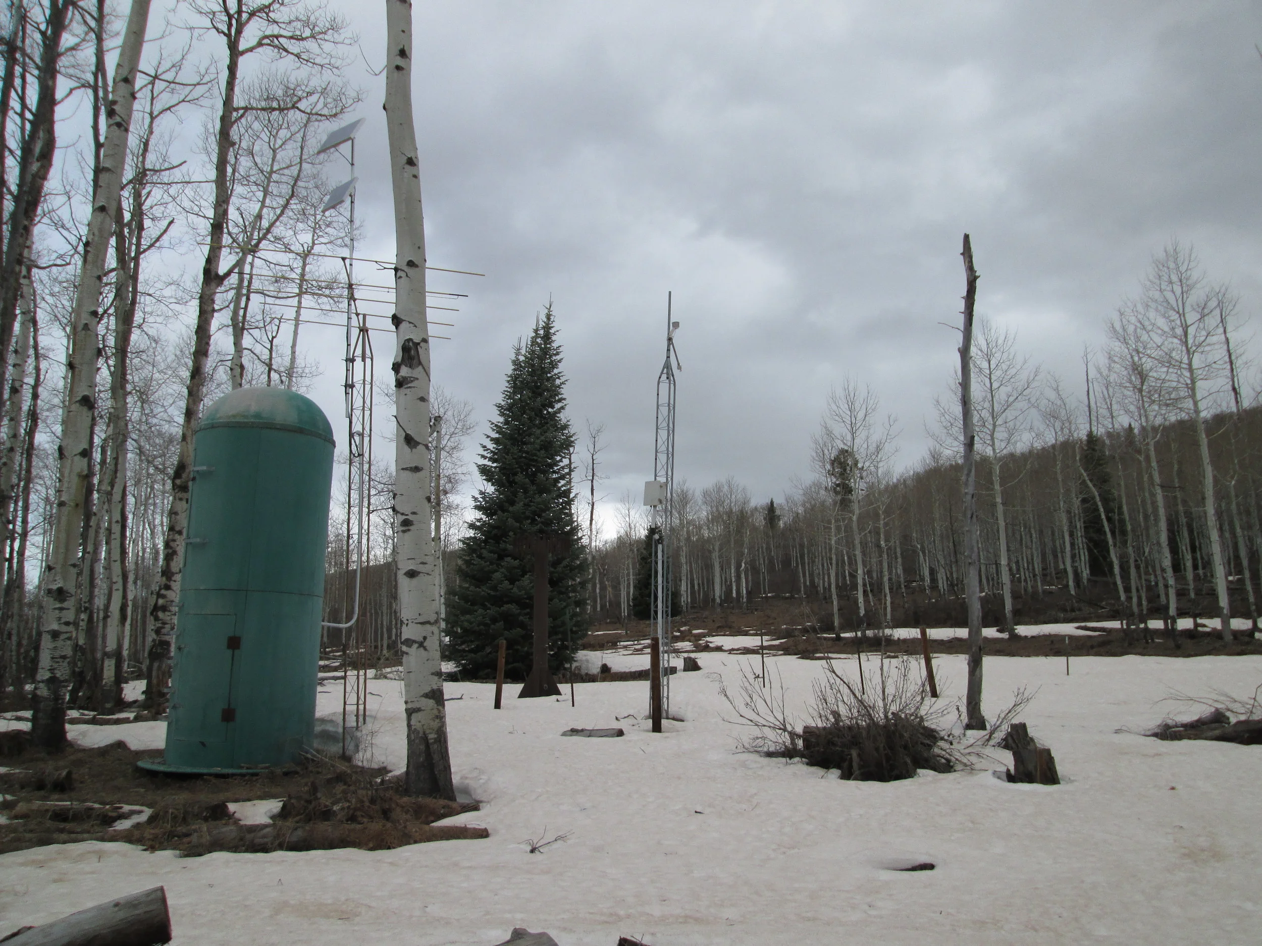 The McClure Pass Snotel station with very thin snowcover, and the dry CODOS snow profile slope in the distance, directly behind the center mast. 