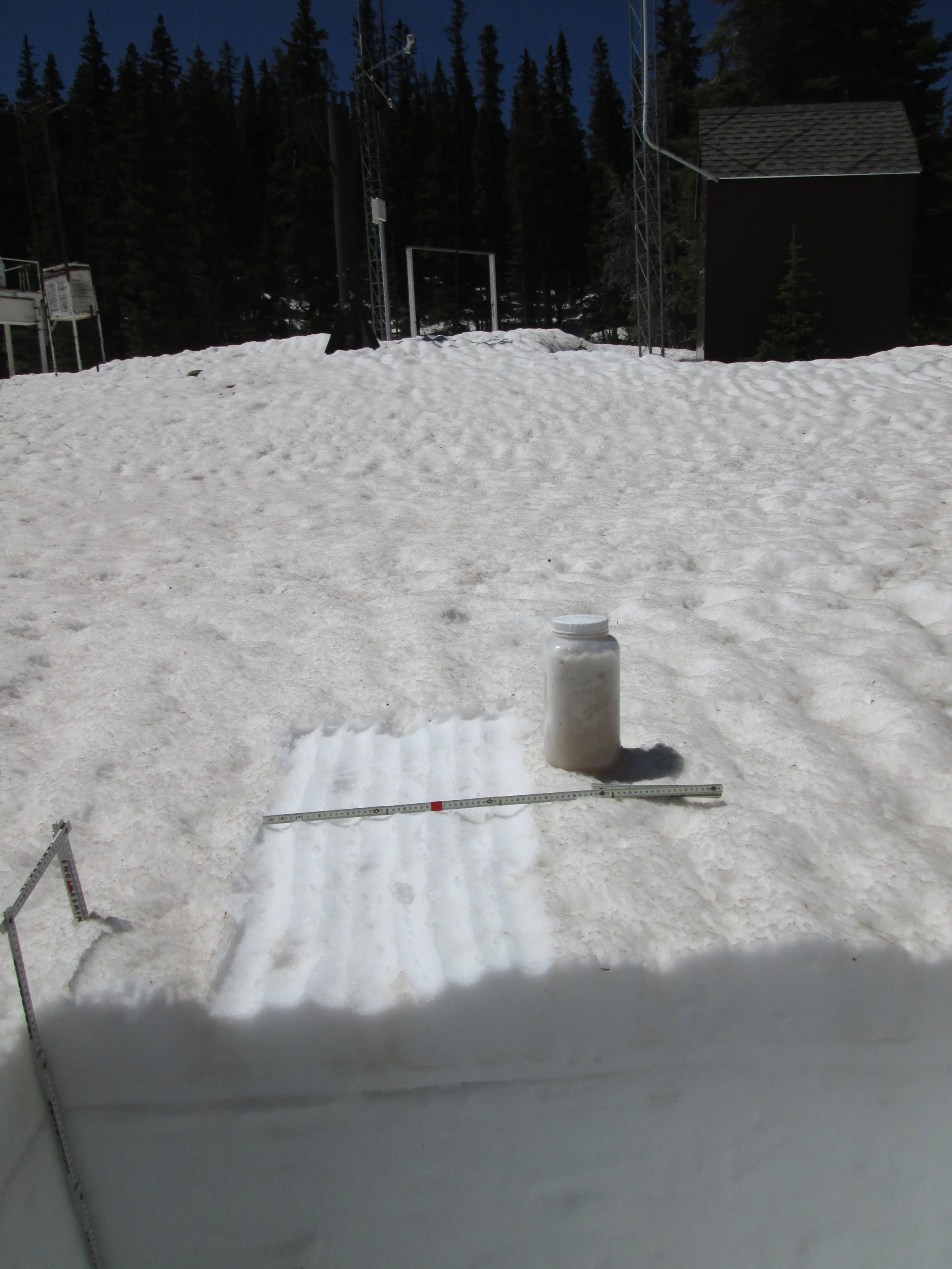 The 35” deep snow pit at Berthoud Summit on June 3 contained 15.5” of SWE, almost exactly matching the SWE being reported at the time by the Snotel just a few yards away. Merged dust containing at least events D3, D4, and D8 was exposed at the surface and an ‘all layers merged’ (ALM) sample was collected from an area measuring 1.00 m x 0.48 m, or 0.48 m2. Dirty melt water from the snow surface had percolated downward in “preferred flow channels” into the underlying clean snowcover before spreading laterally at a layer boundary within the snowpack and creating a layer of dust-stained slush, as seen here a few inches below the surface in the snow pit face. Nonetheless, the ALM sample did capture the vast majority of the merged dust material, for analysis of its chemical and other properties. 