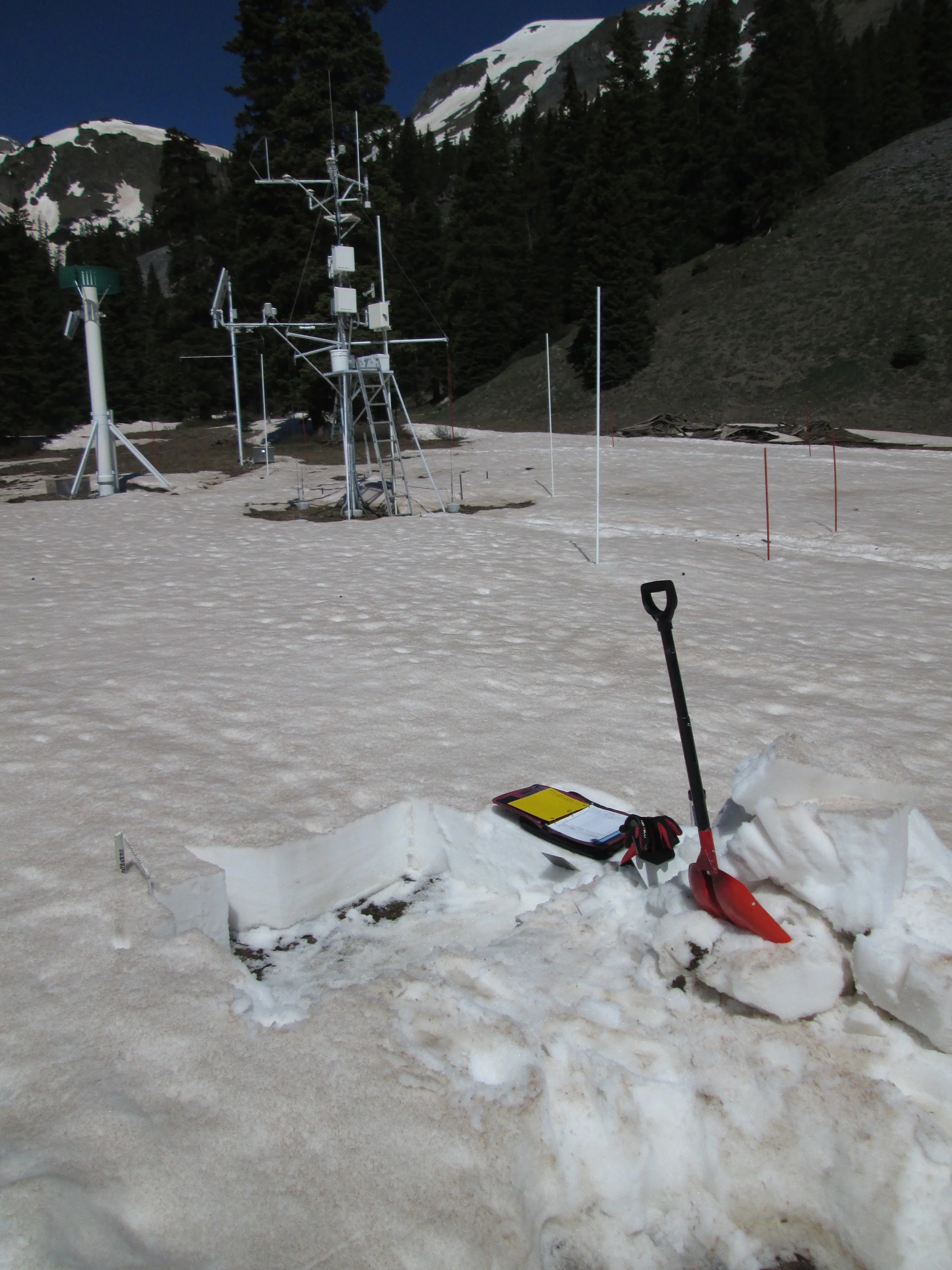 Our final snow profile of the season at Swamp Angel Study Plot (SASP) on June 5 documented the loss of almost 30” (75 cm) of snow depth and 13.9” (352 mm) of SWE since the preceding snow profile on May 28. Even with a few lingering inches of clean snowfall from the Memorial Day weekend storm, and that brief restoration of high snow albedo, snowmelt had averaged 1.7” (44mm) of SWE per day during that 8-day interval. Snowmelt around the instrument mast was somewhat more rapid and had already revealed bare ground. The remaining snowcover and 5” of SWE seen in this snow pit was all gone within 48 hours.