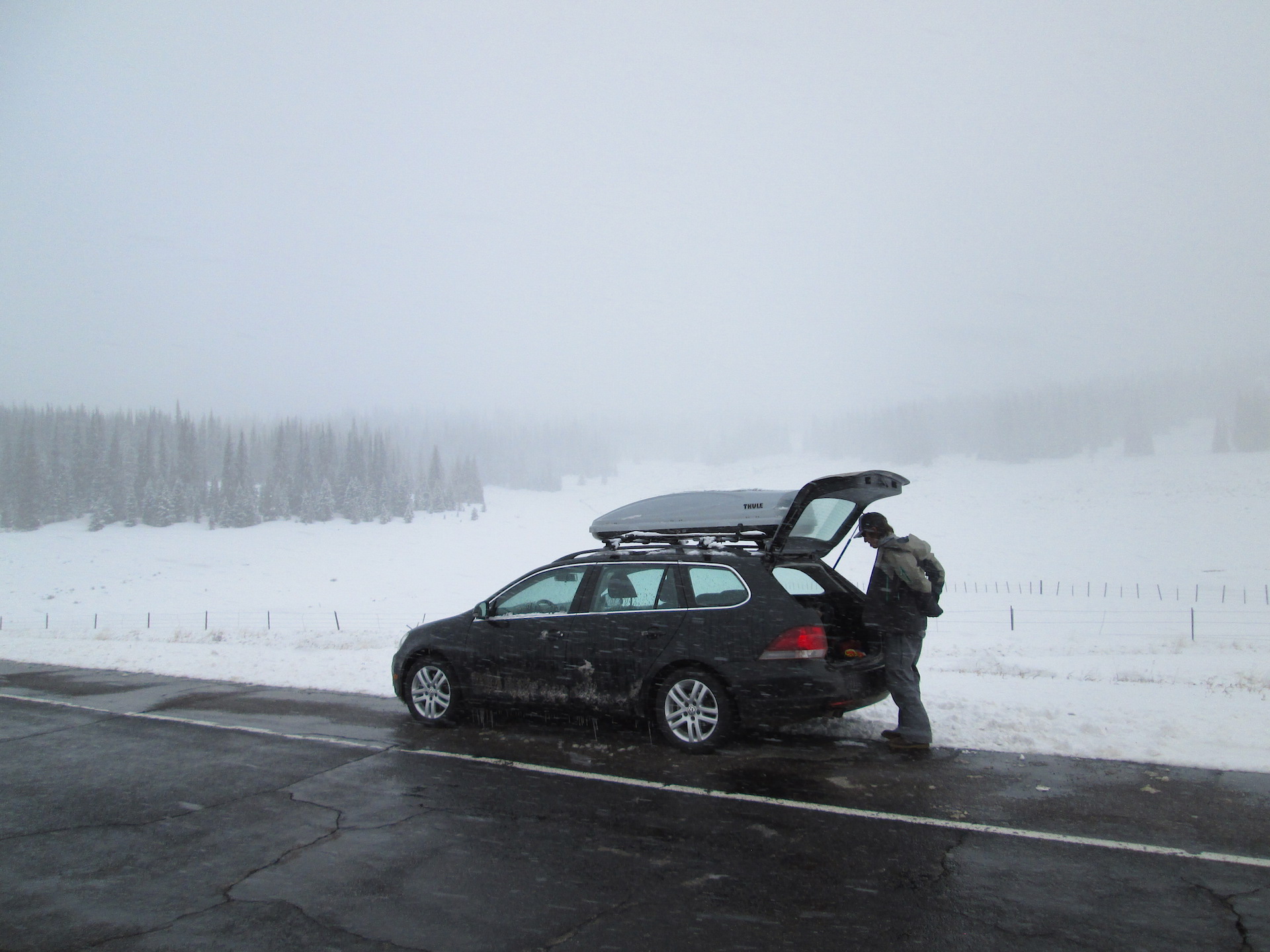Jay Welz gears up for the Spring Creek Pass snow profile to be performed on the open slope seen in the distance, to the left of the car. 