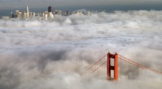 Fog around Golden Gate Bridge and city skyline