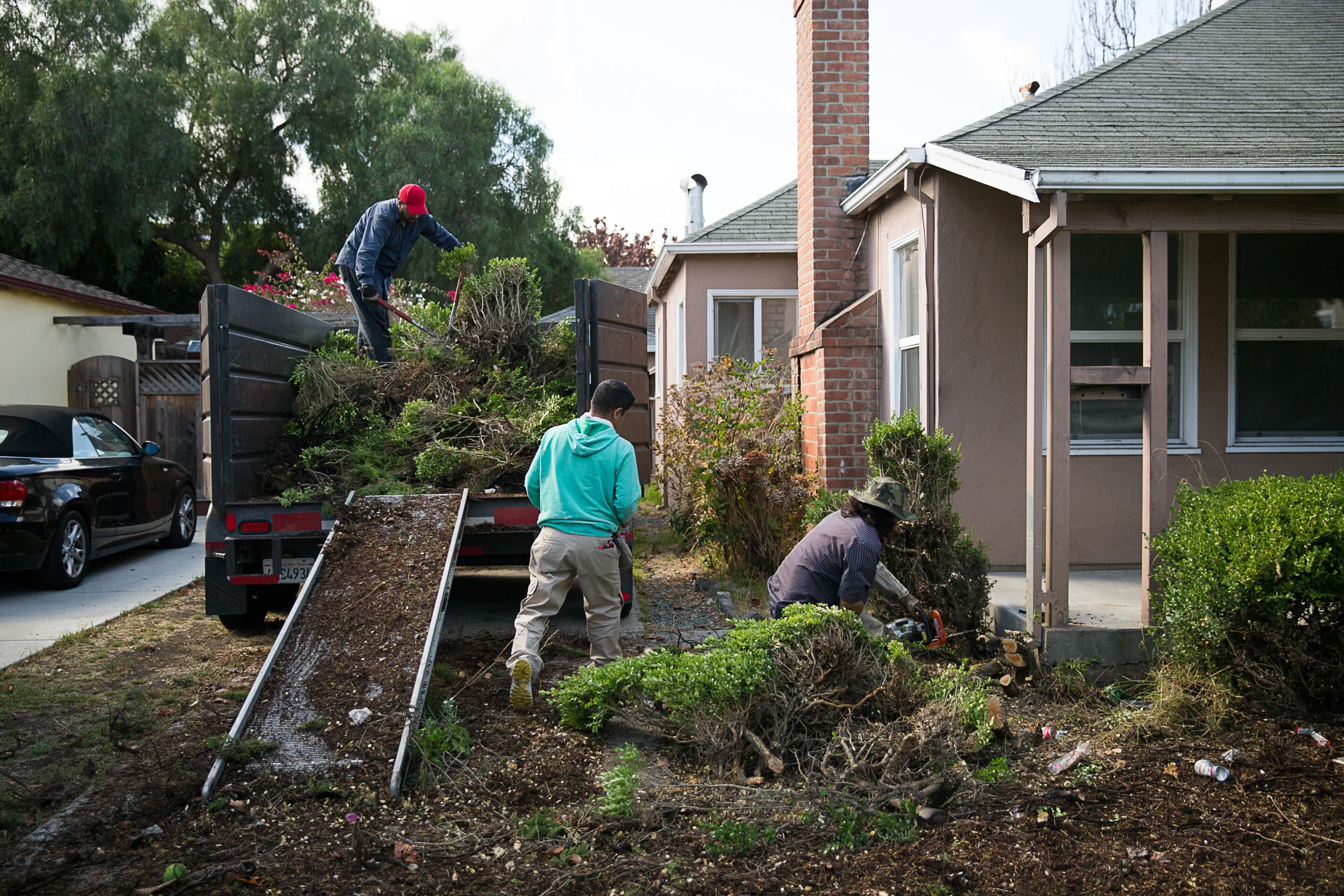 The landscaping crew rids the front yard of unsightly junipers to enhance its curb appeal.