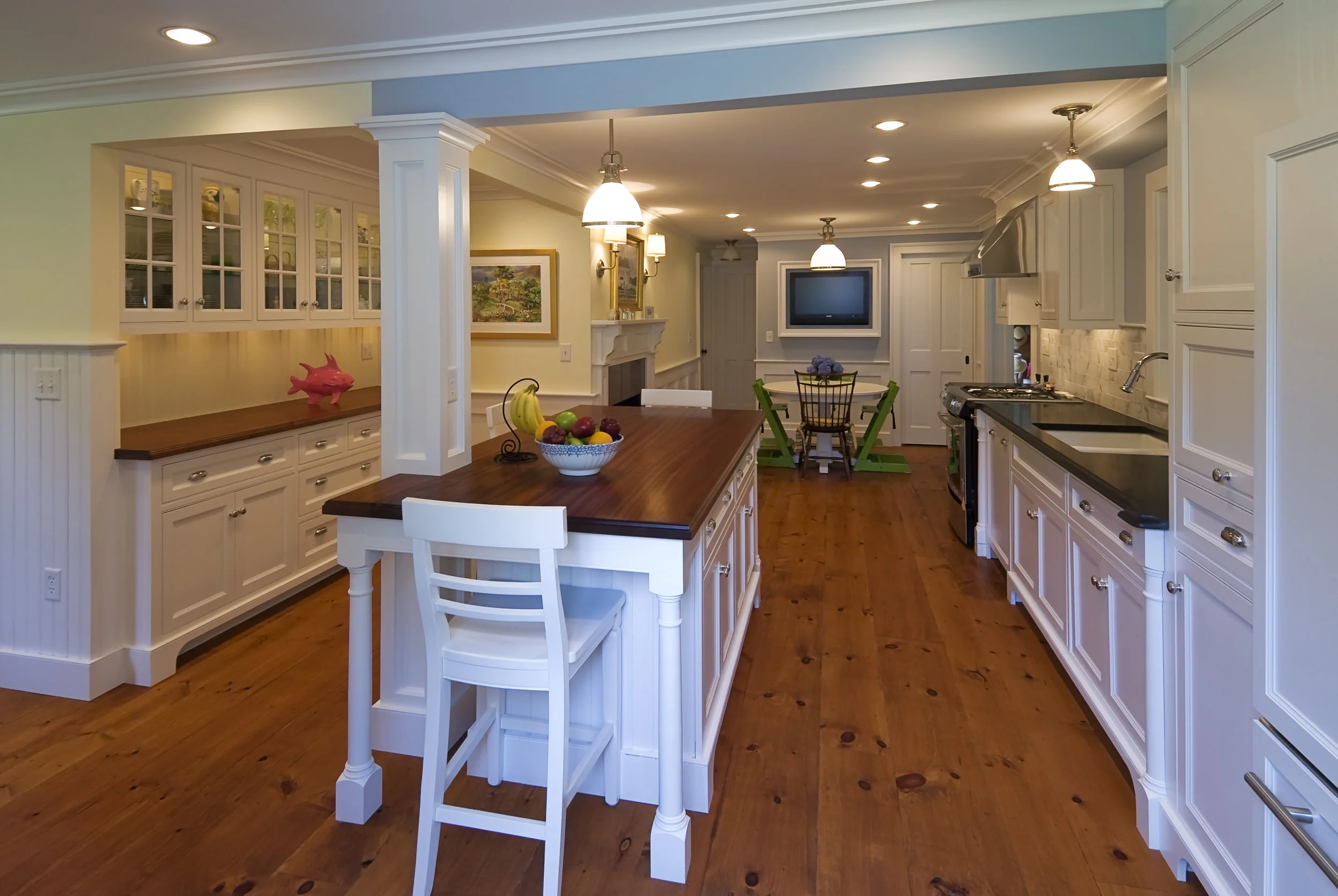 New mahogany counters are a great contrast to the bright white cabinets while complimenting the wide oak wood floors.