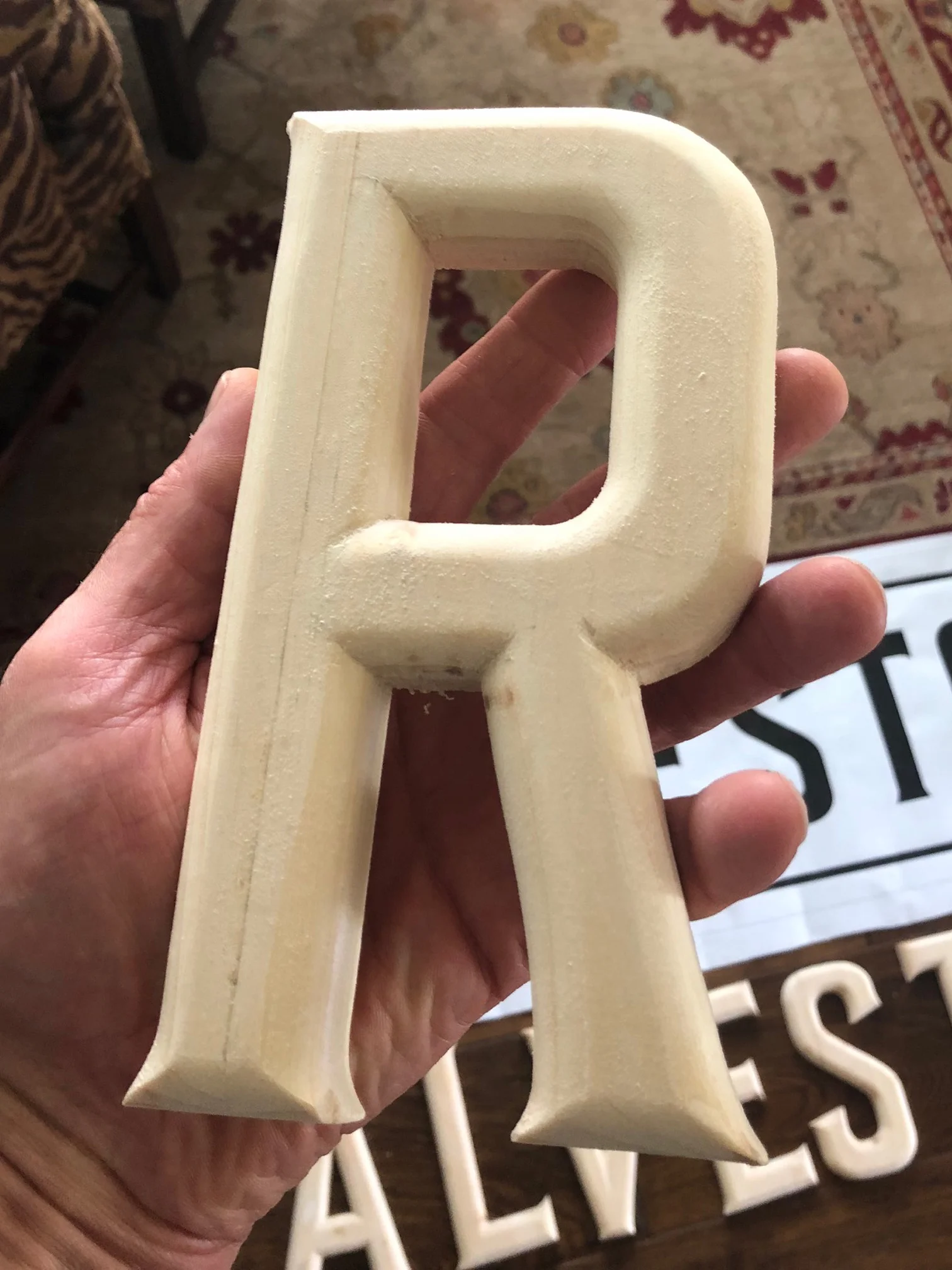 Letters rounded over with a radius bit and a sharp chisel for the corners.
