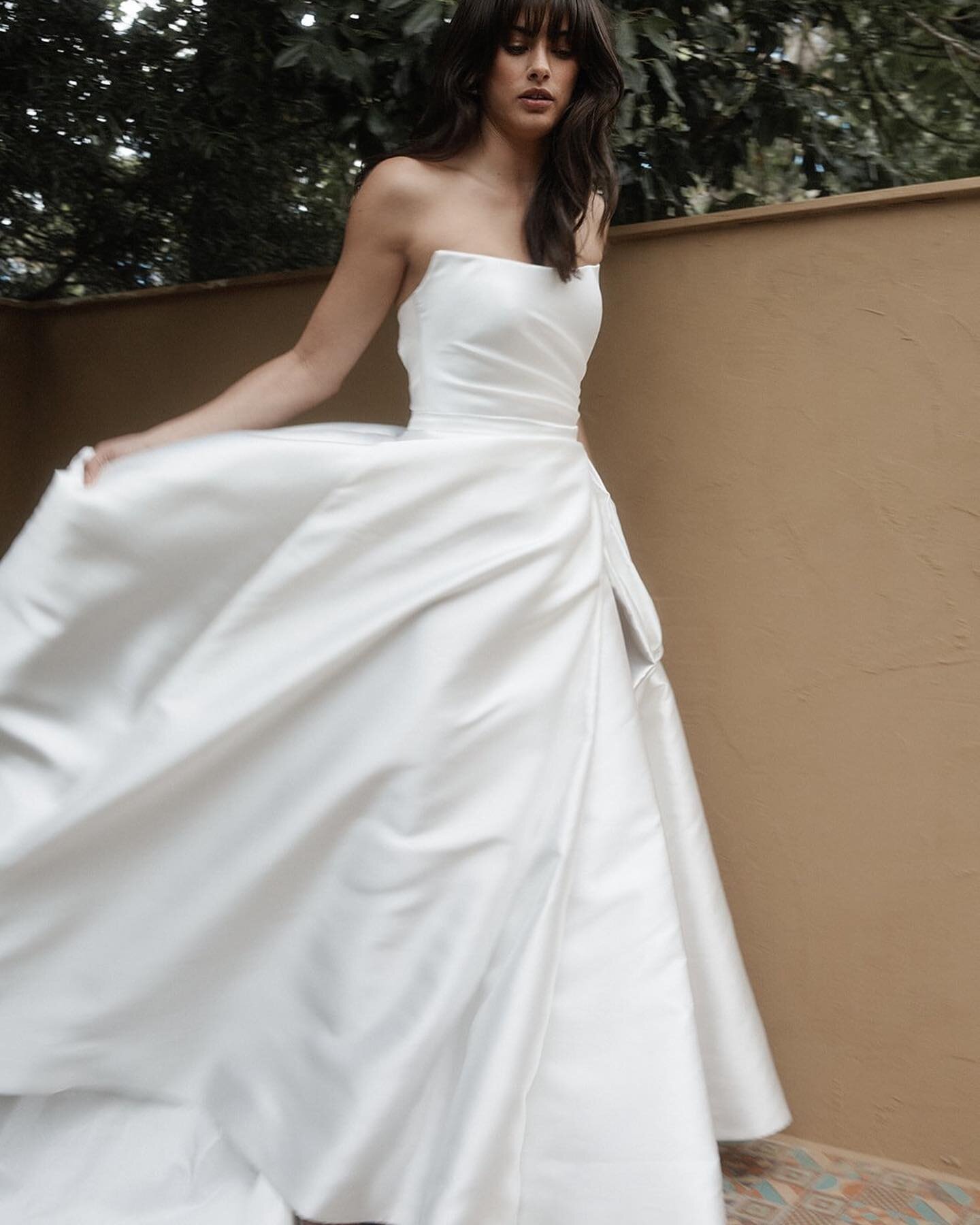 Ultra-romantic with an abundance of chic, The Paris delivers a dramatic look with her hand-draped bodice that sculpts at the waist, and her head turning skirt featuring a pleated split (and yes, there&rsquo;s pockets too&hellip;)