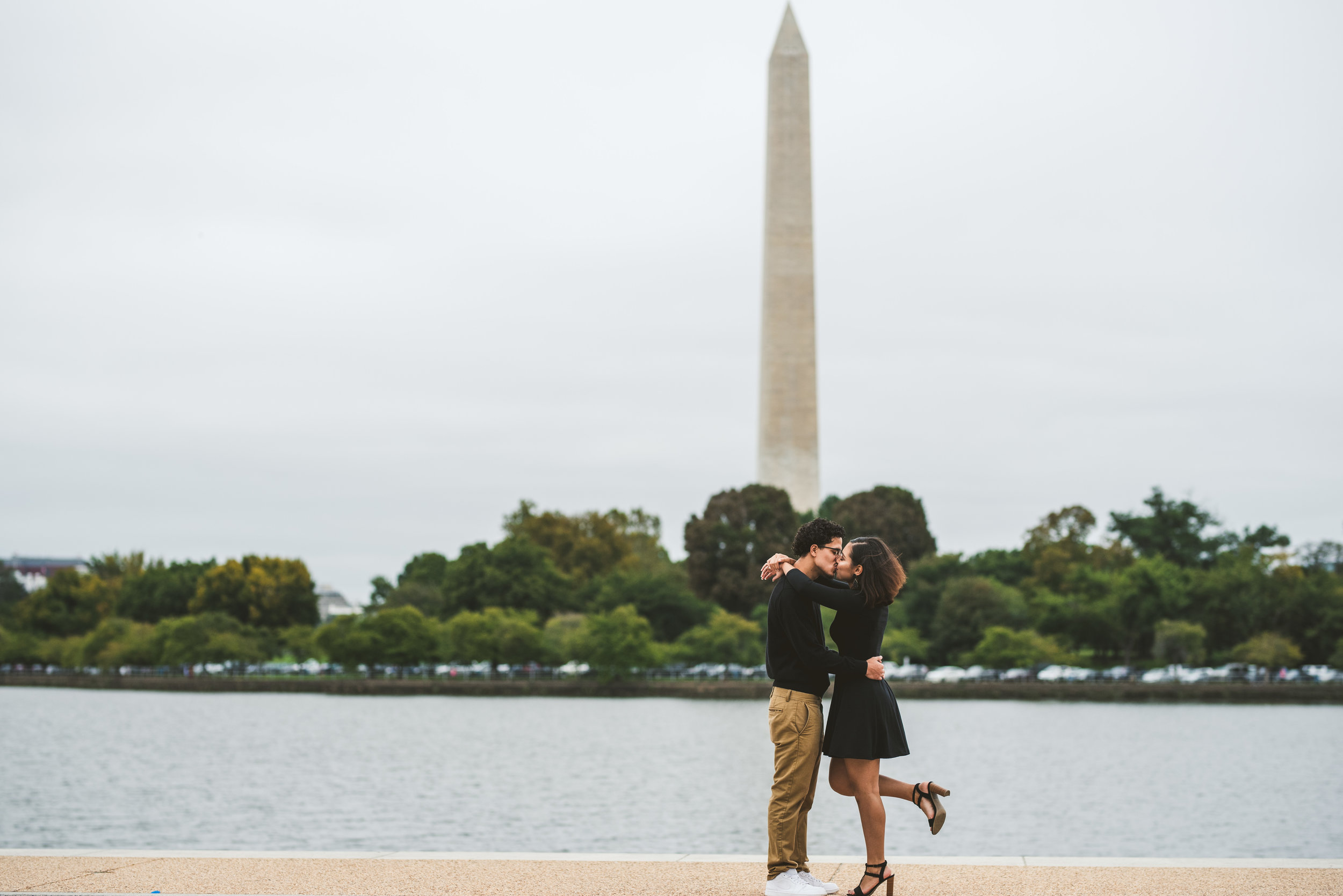 Couple kissing infront of the Washington D.C Monument in the Jefferson Memorial 