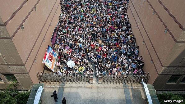 Candidatos a cargo no serviço público chinês se aglomeram na entrada do local do exame. Foto: Getty Images