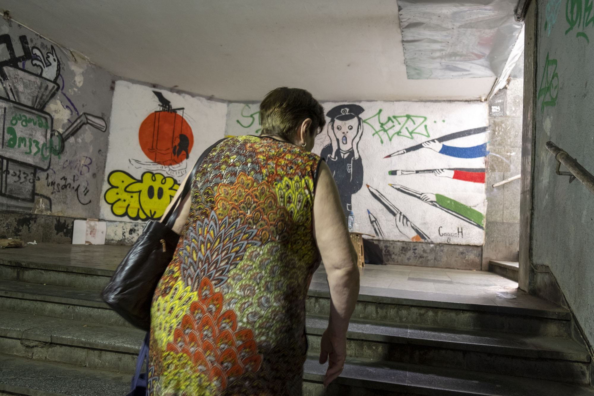 woman walking up stairs with graffiti.jpg
