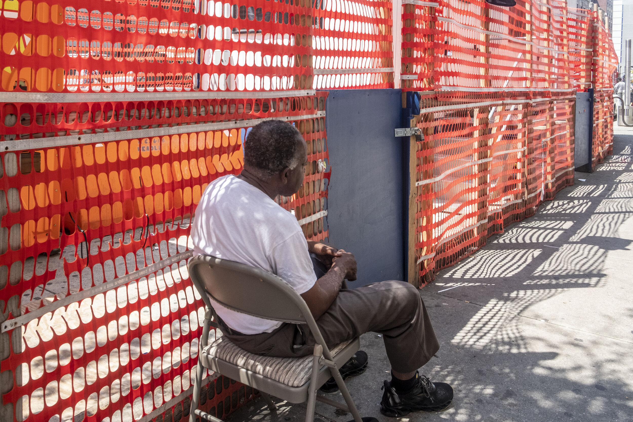 man sitting by caution fence.jpg