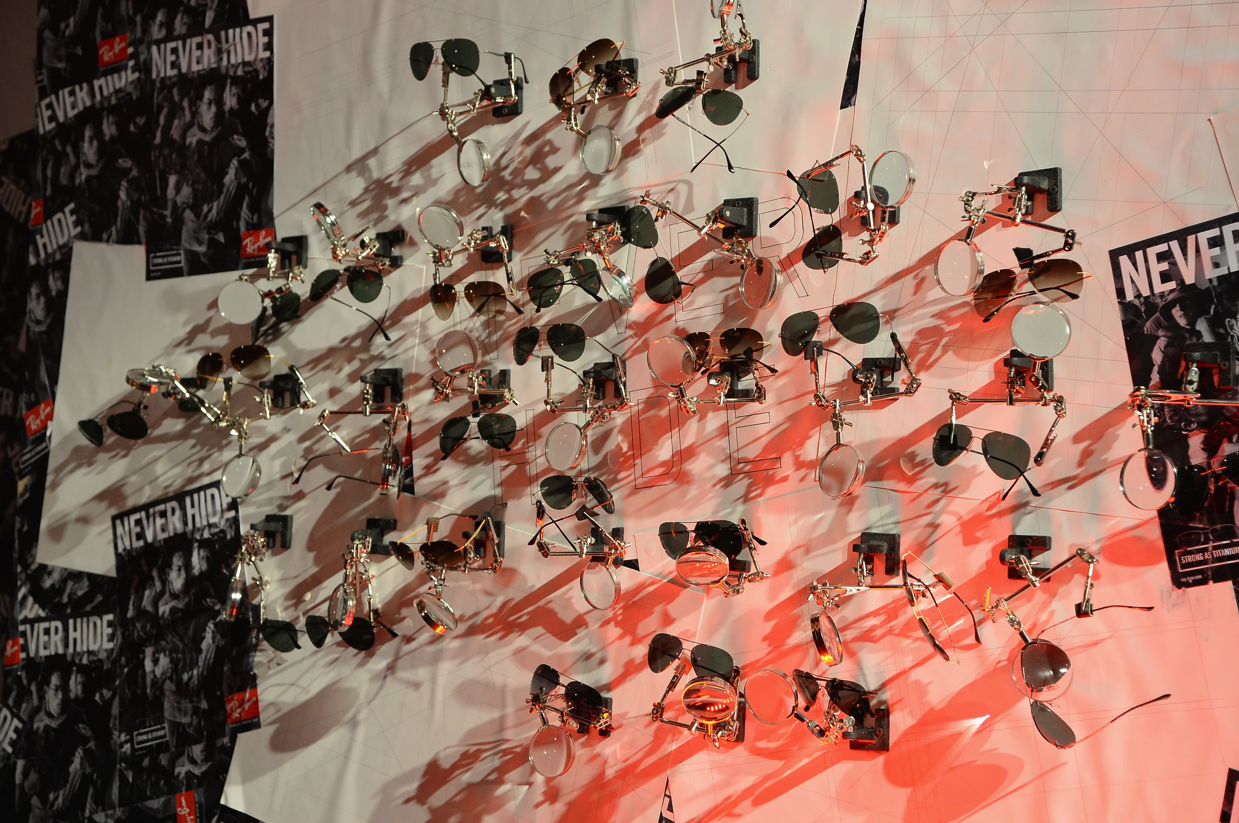  Titanium sunglass display was a wall mounted array of soldering clamps with magnifying glasses on a wall-flat fly-posted with drafted pages and campaign imagery.&nbsp; 