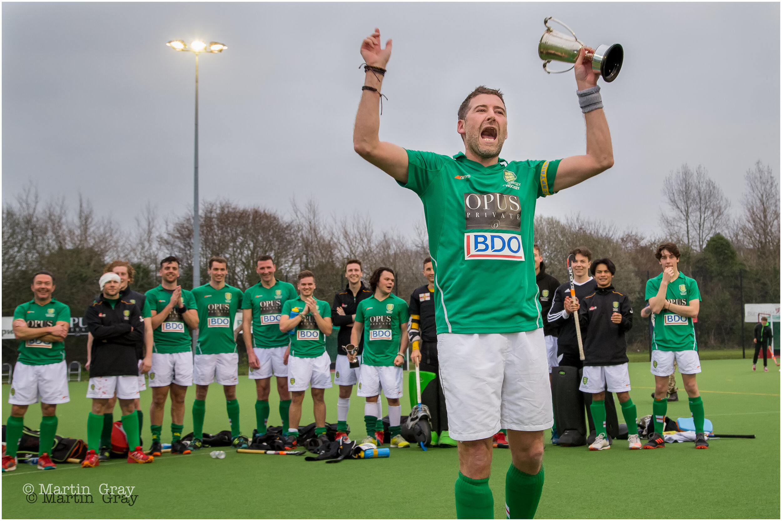 Guernsey Ist's Mens Captain Adie Peacegood lifts the trophy-4673.jpg