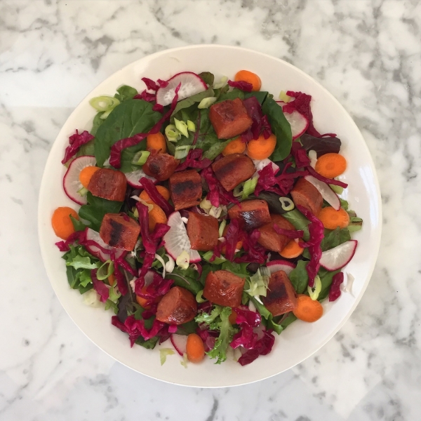 Fork in the Road pastured-beef hot dogs, carrots, radishes, purple sauerkraut, over greens