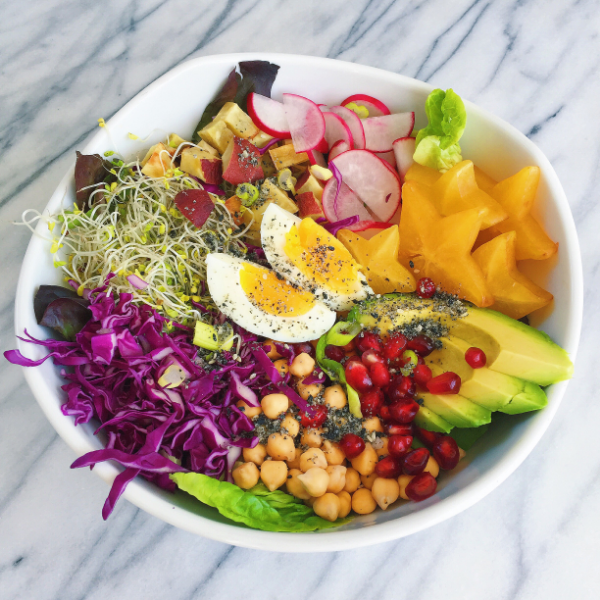 Sprouted chickpeas, pomegranate seeds, avocado, starfruit, radish, sweet potato, broccoli sprouts, red cabbage, green onion, egg, greens.
