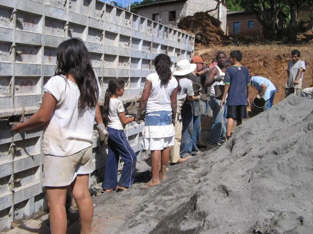 Volunteers form a line to pass buckets of wet cement.