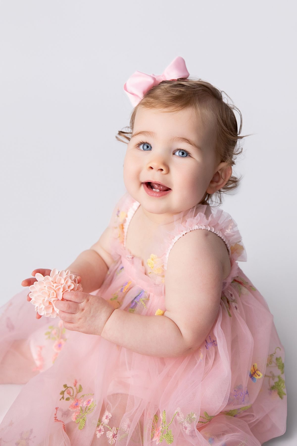 Close up portrait of smiling baby in pink floral dress, Sarah Kane Photography