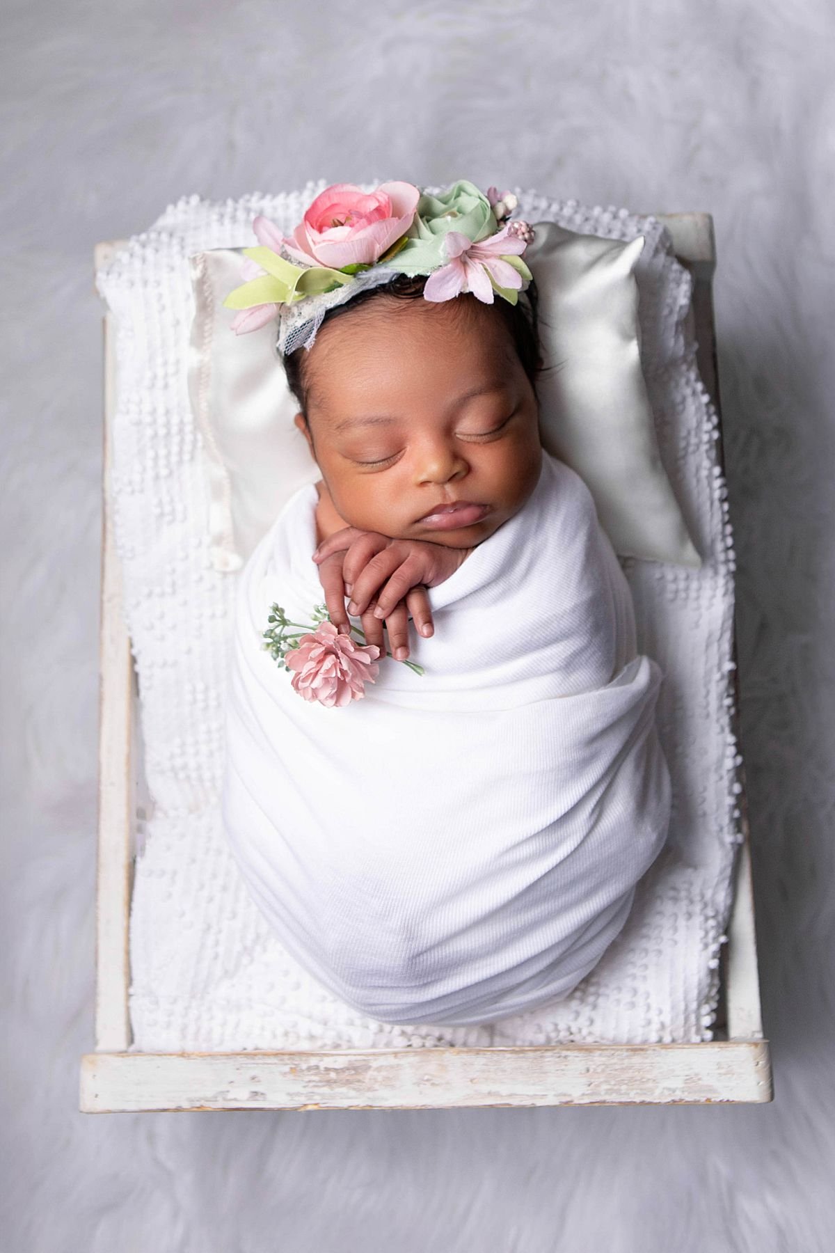 Overhead newborn portrait of a sleeping baby wrapped in white in a white wooden box photographed by Sarah Kane Photography in Chesterfield Virginia outside of Richmond