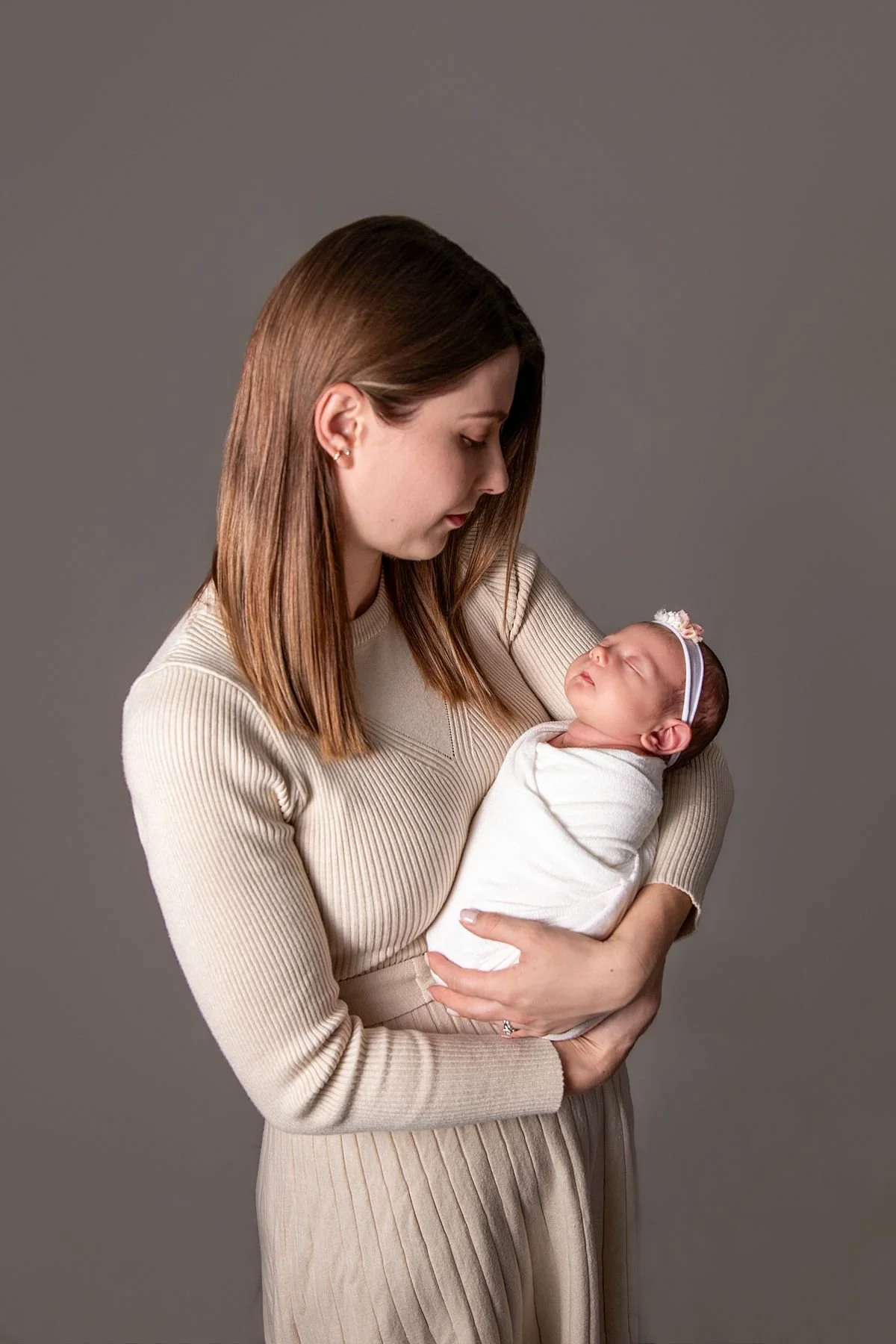 Mom gazing at sleeping swaddled newborn in studio portrait, Sarah Kane Photography