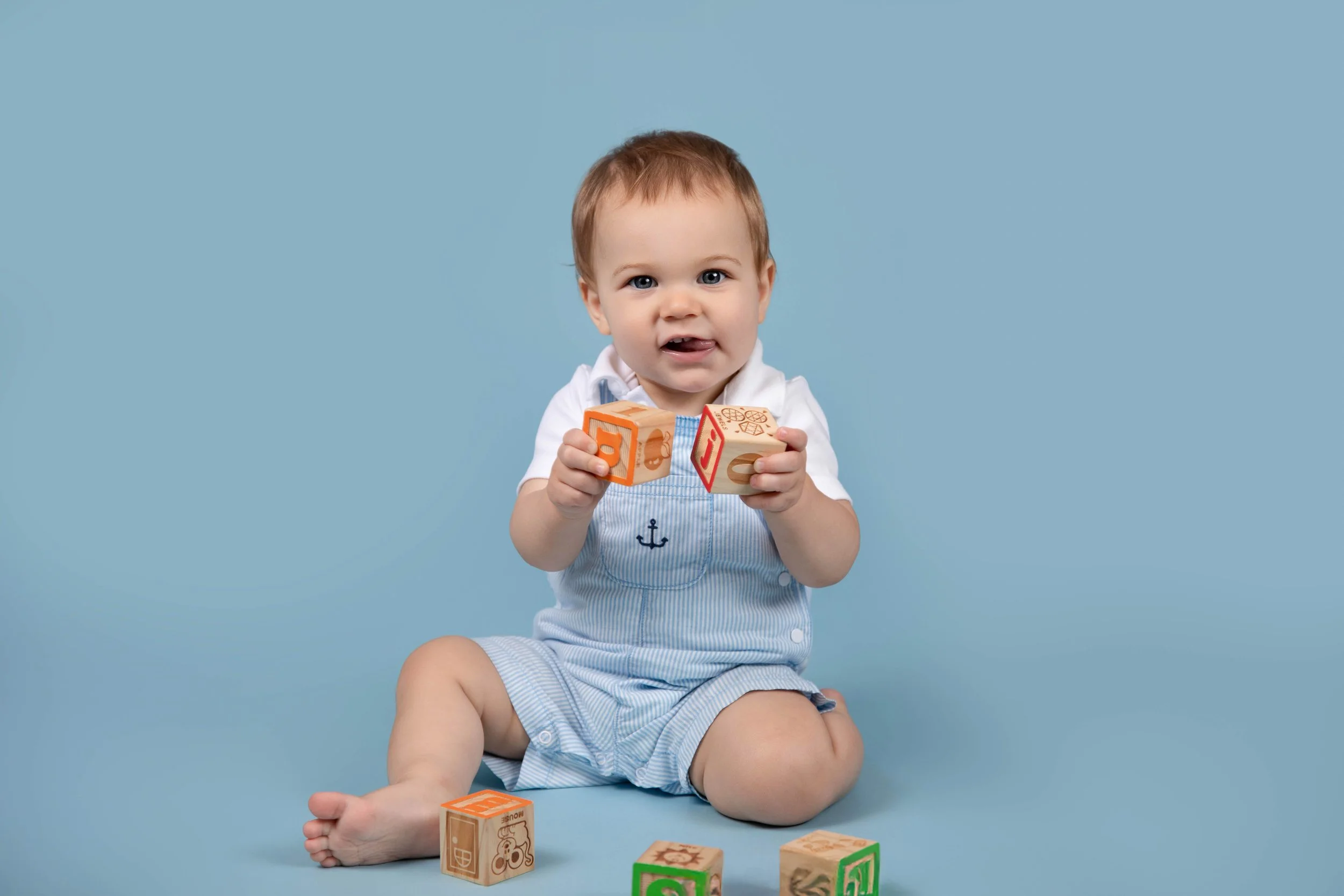 1 year baby milestone baby in blue with blocks