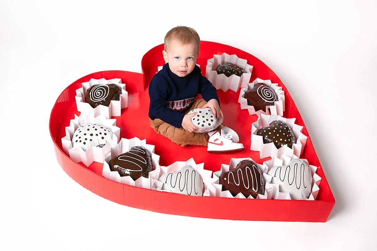 Valentine Children’s Mini Portrait Sessions near Richmond VA Little boy sitting in a box of chocolates