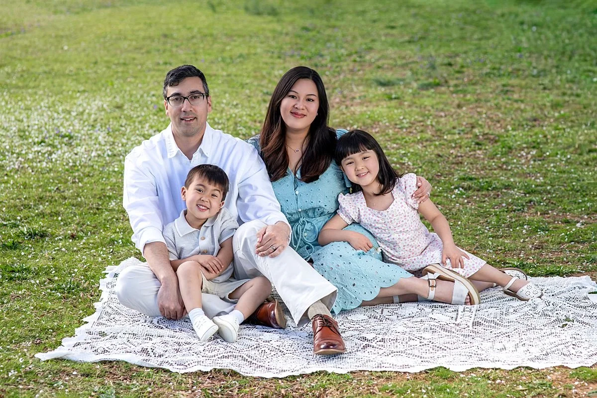 Family sitting together on a lace blanket during a spring mini session, Sarah Kane Photography, Richmond, Virginia