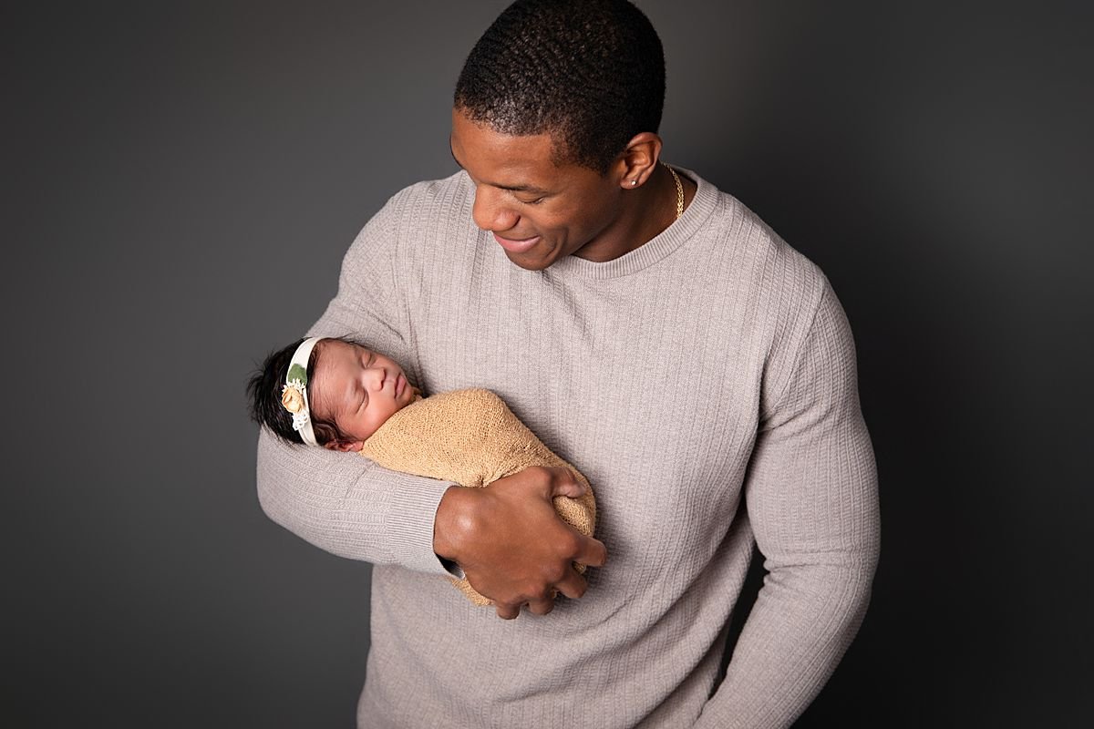 Father smiling at newborn twin,  Sarah Kane Photography