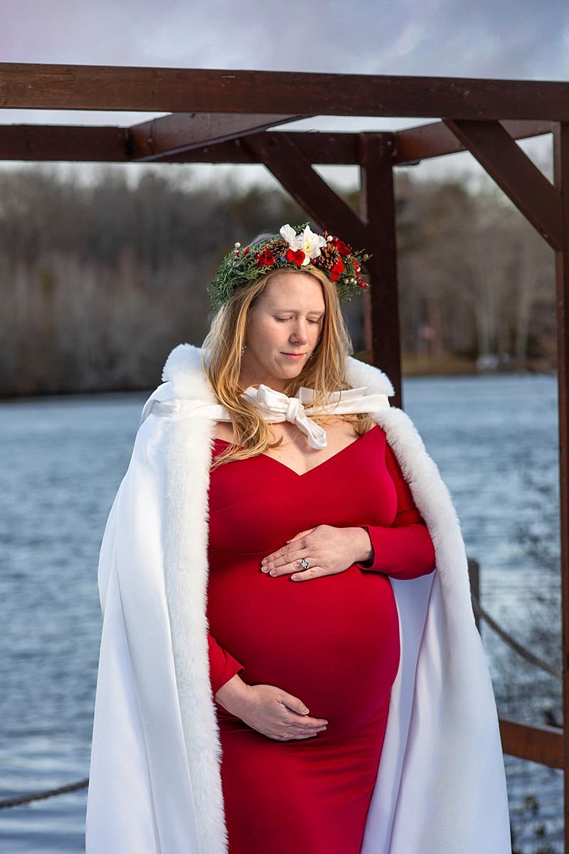 Outdoor Winter Maternity Session, Powhatan VA, Pregnant Woman in a Red Gown Holds Her Belly Wrapped in a White Coat