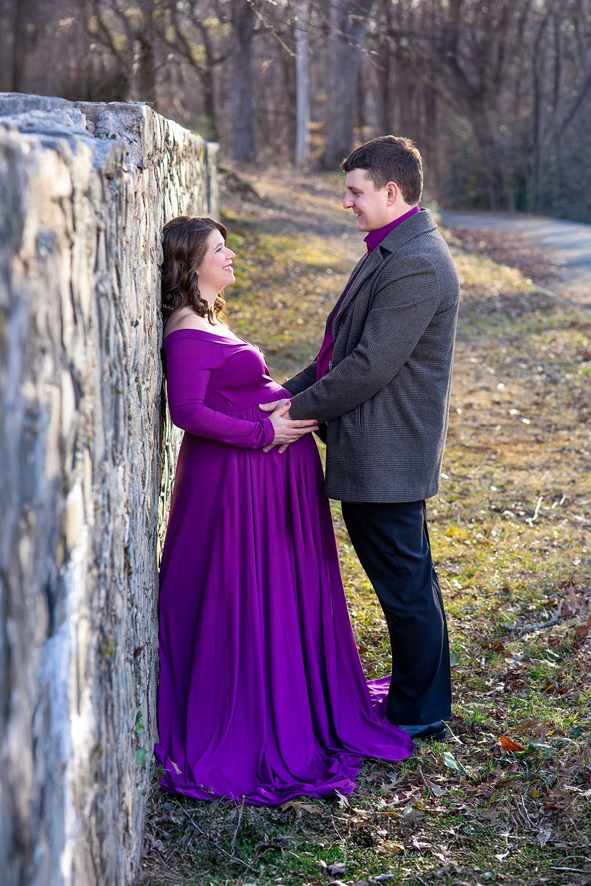 Expecting couple smiling together against a stone wall at The Carillon, Richmond VA, Sarah Kane Photography